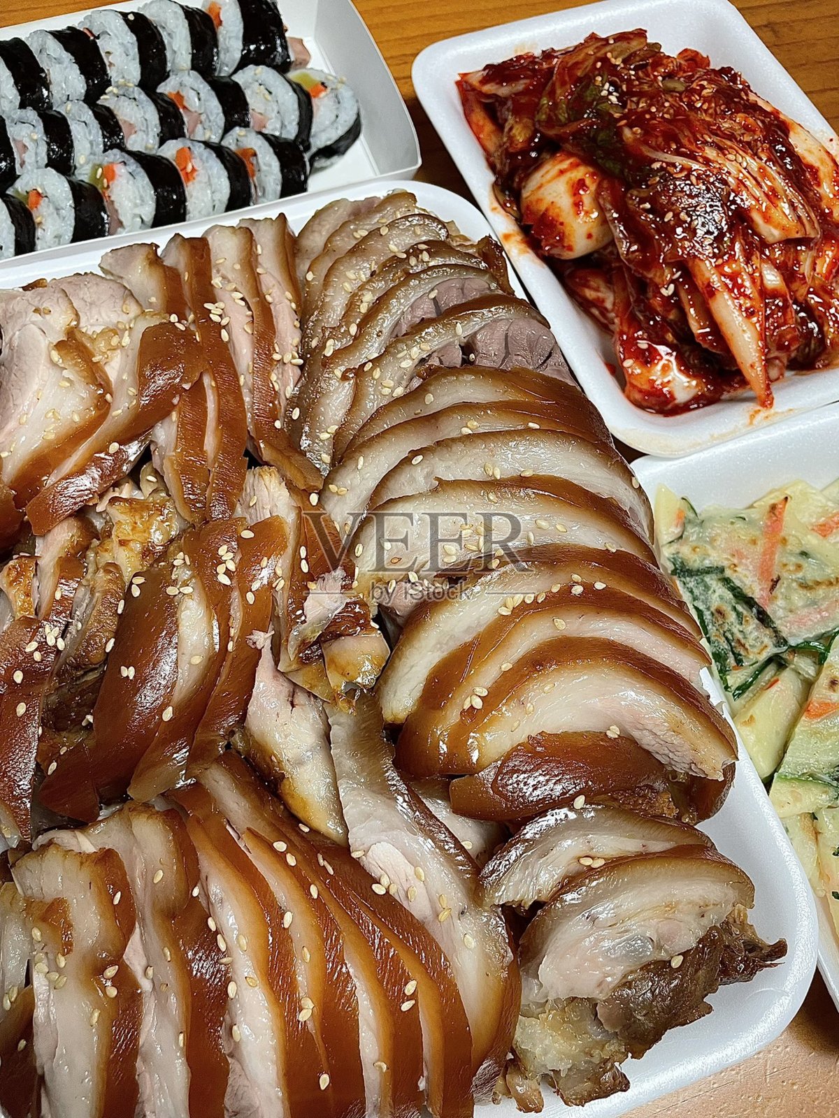 猪蹄膀是一道韩国菜，采用酱油、大蒜和香料慢炖而成，肉质鲜嫩，味道丰富。通常与生菜包、大蒜和酱料一起享用，成为一道美味丰盛的餐点。照片摄影图片