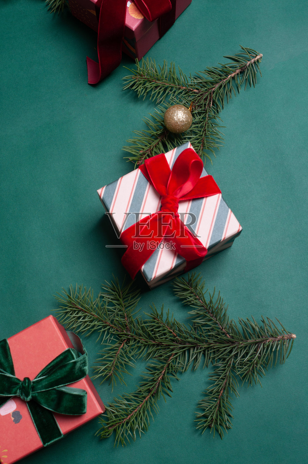 美丽的圣诞节背景平铺，绿色底上有红色丝带的礼物和松枝照片摄影图片
