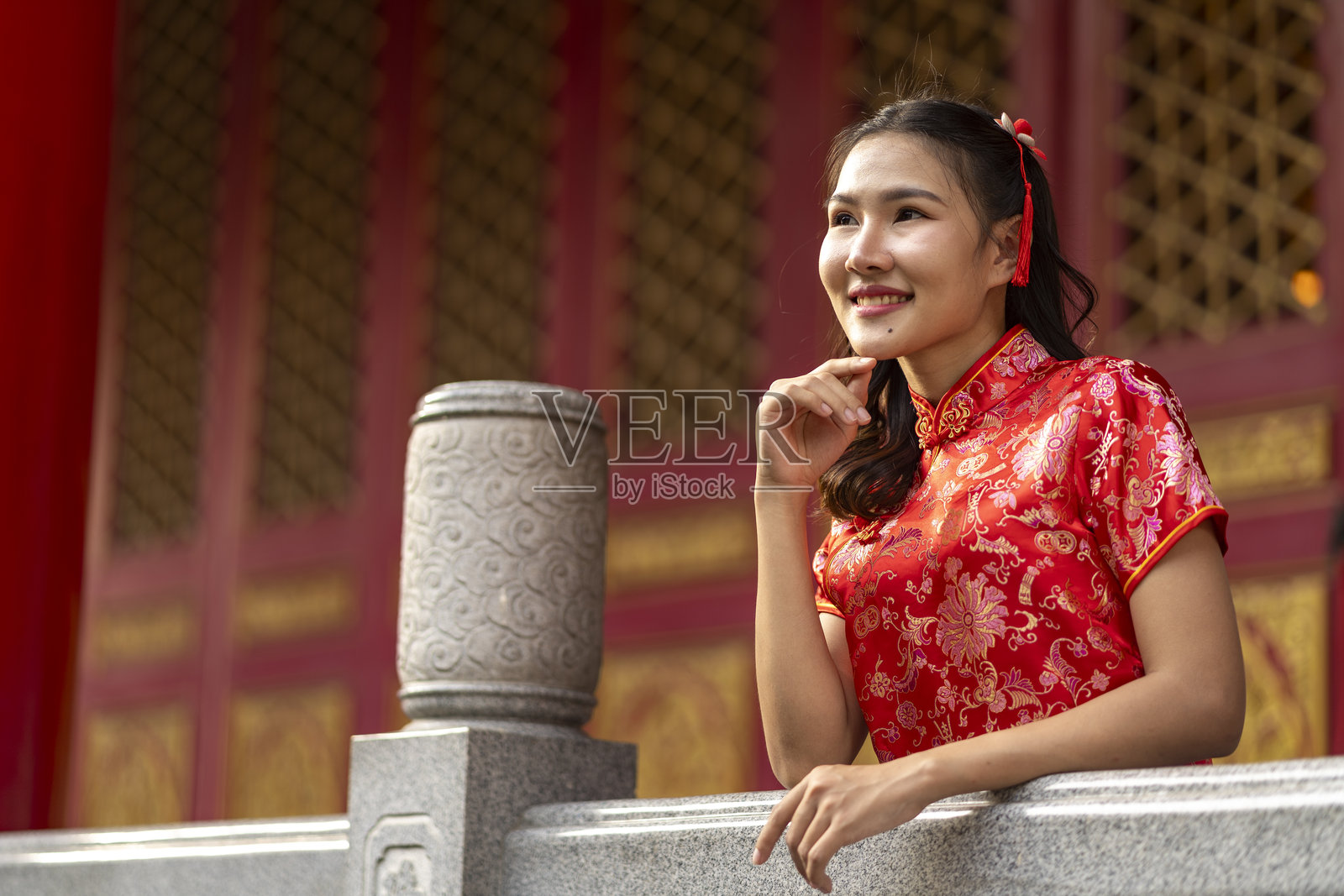 身穿红色旗袍的年轻美丽女性在传统中国寺庙中照片摄影图片