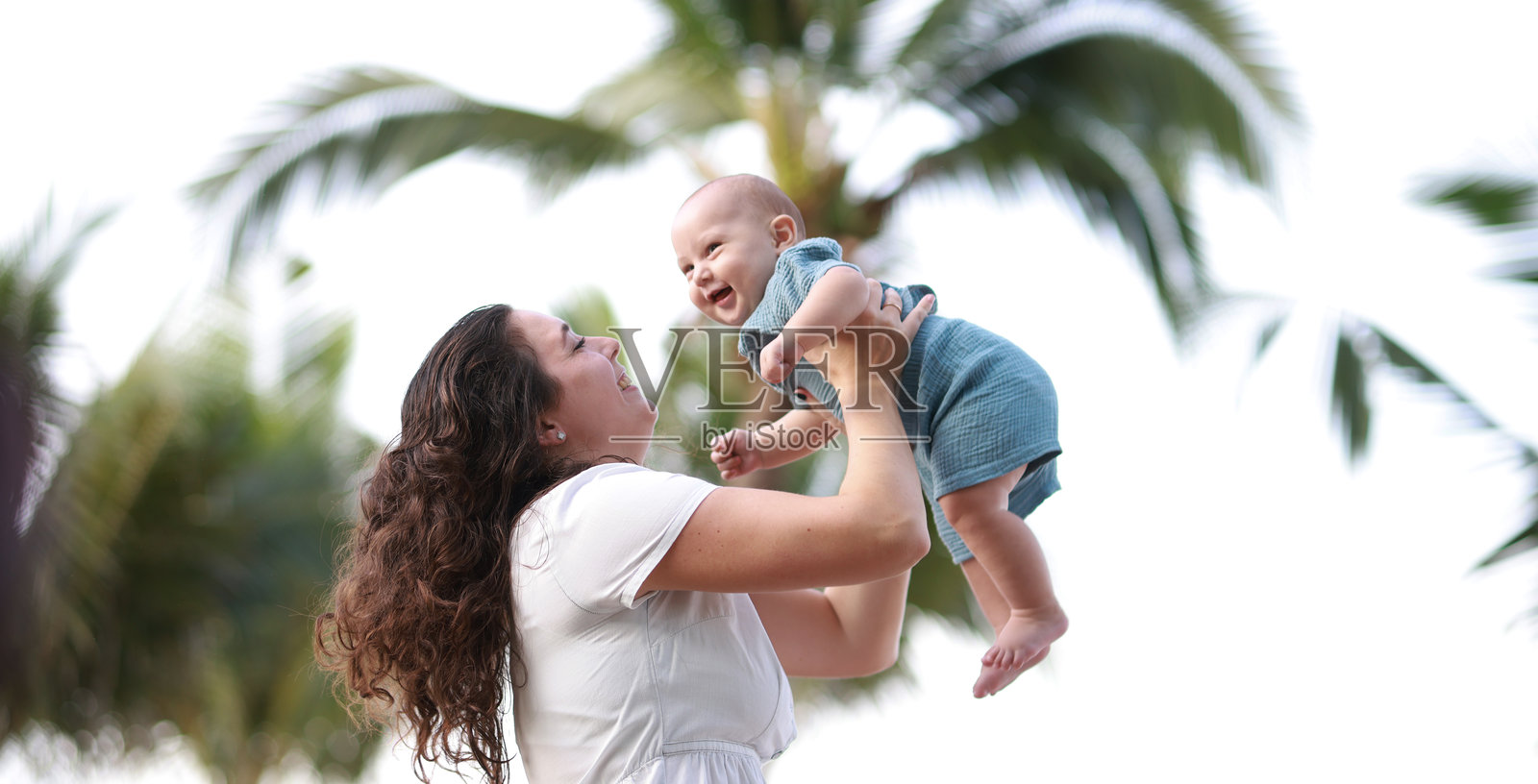 母亲和她的婴儿儿子在夏季假期的海滩上玩耍照片摄影图片