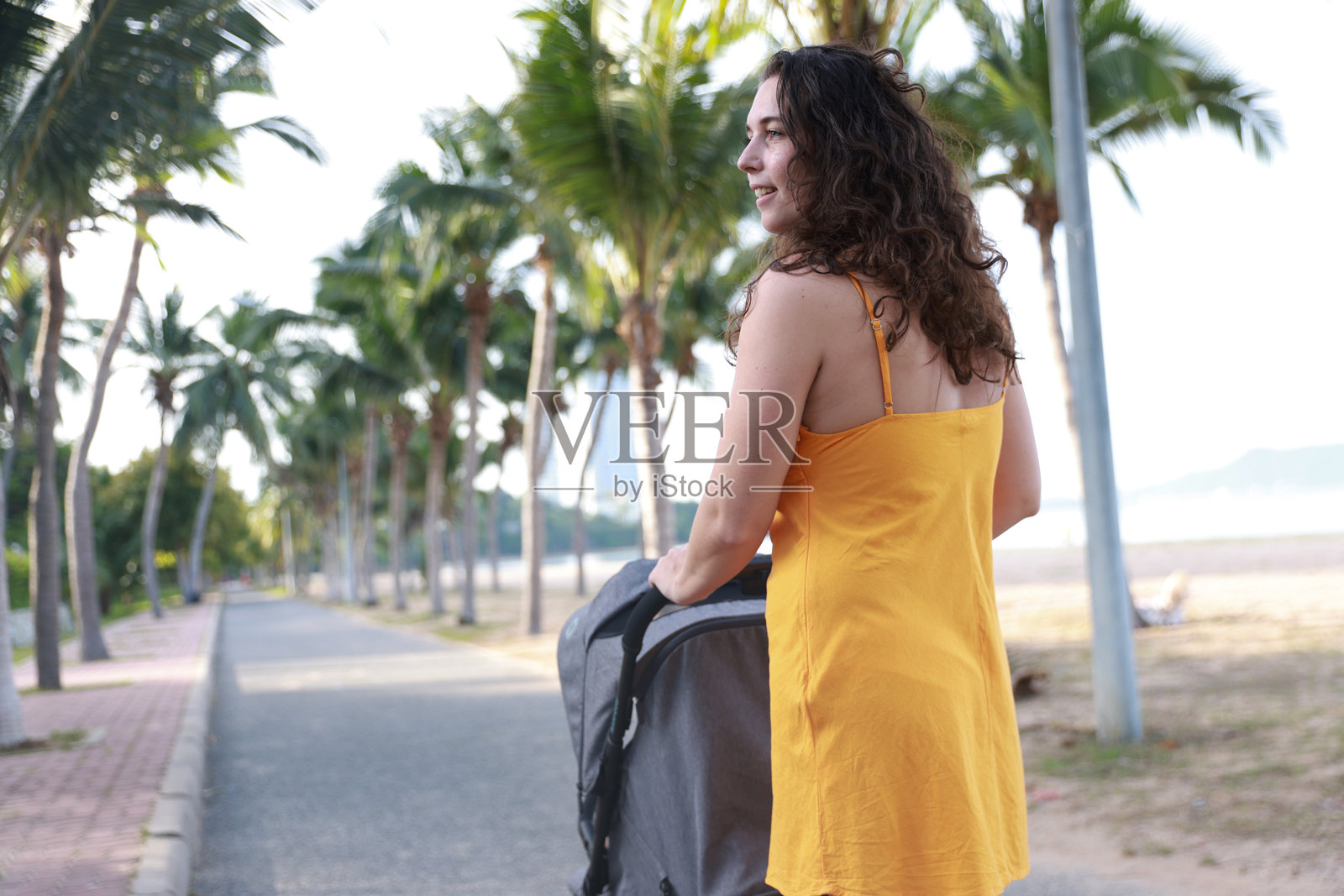 一位快乐年轻母亲在海边沙滩上的肖像。家庭生活方式。母爱的体现。照片摄影图片