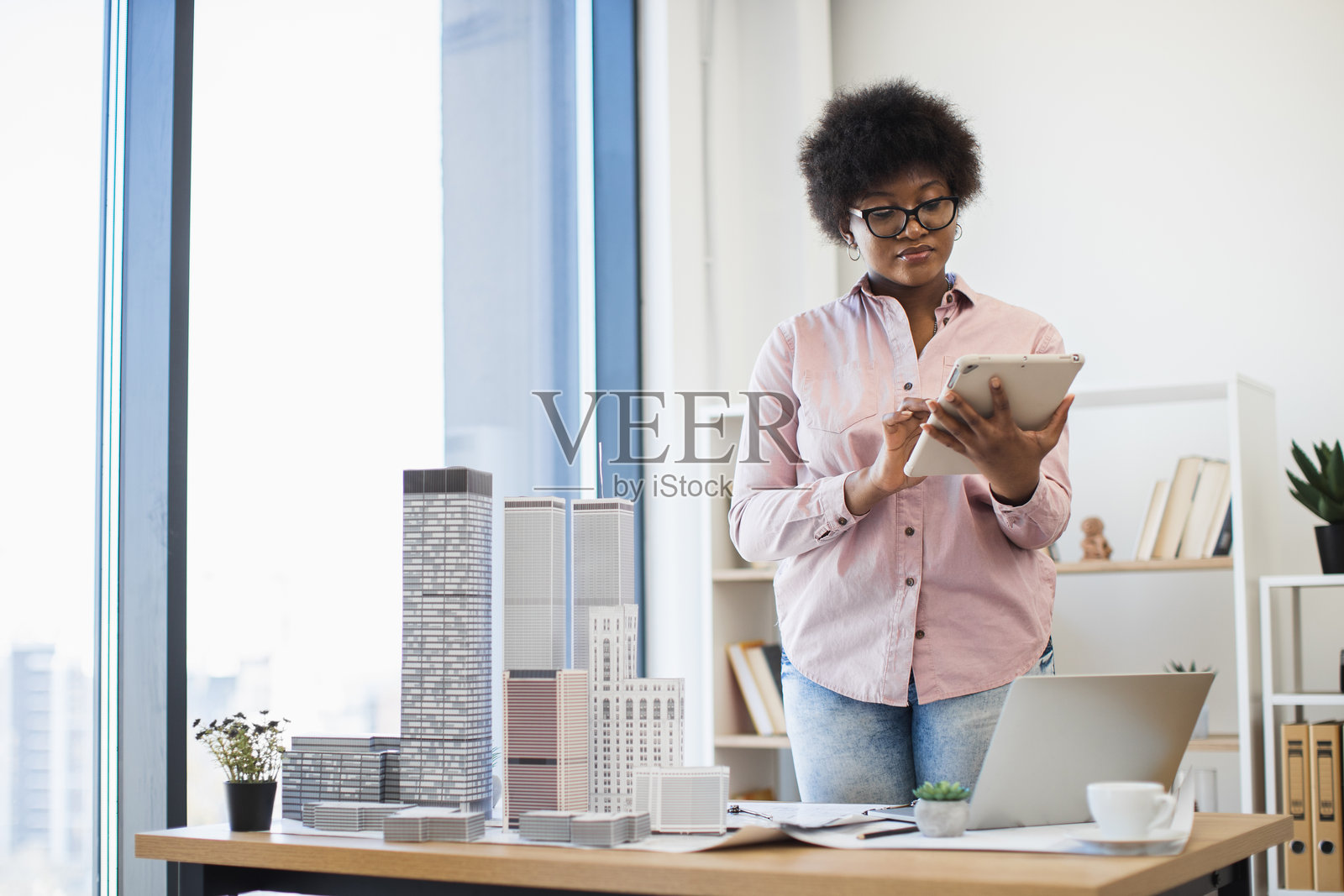 非裔美国女性建筑师在现代办公室环境中使用平板电脑照片摄影图片