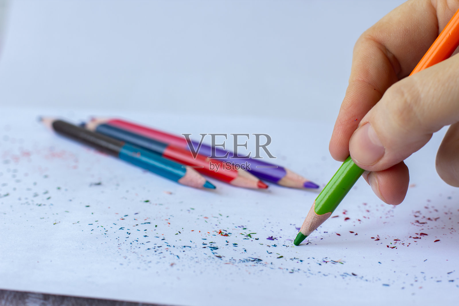 女性手用彩色铅笔在白纸上写字照片摄影图片