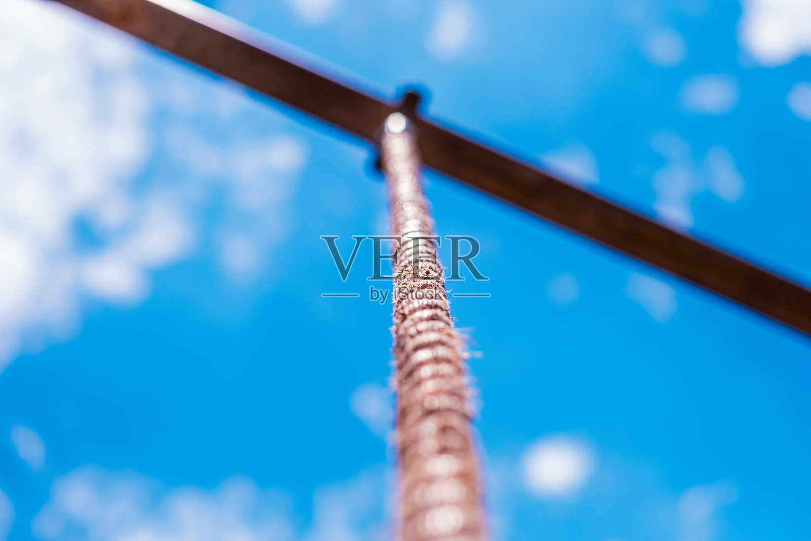 绳索通向明亮的蓝天和蓬松的白云，象征着雄心、挑战和户外冒险。照片摄影图片