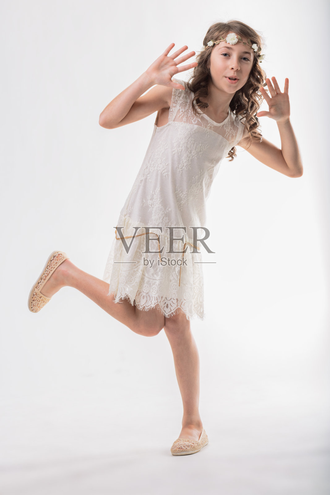 穿着白色裙子的年轻女孩在跳舞和玩耍照片摄影图片