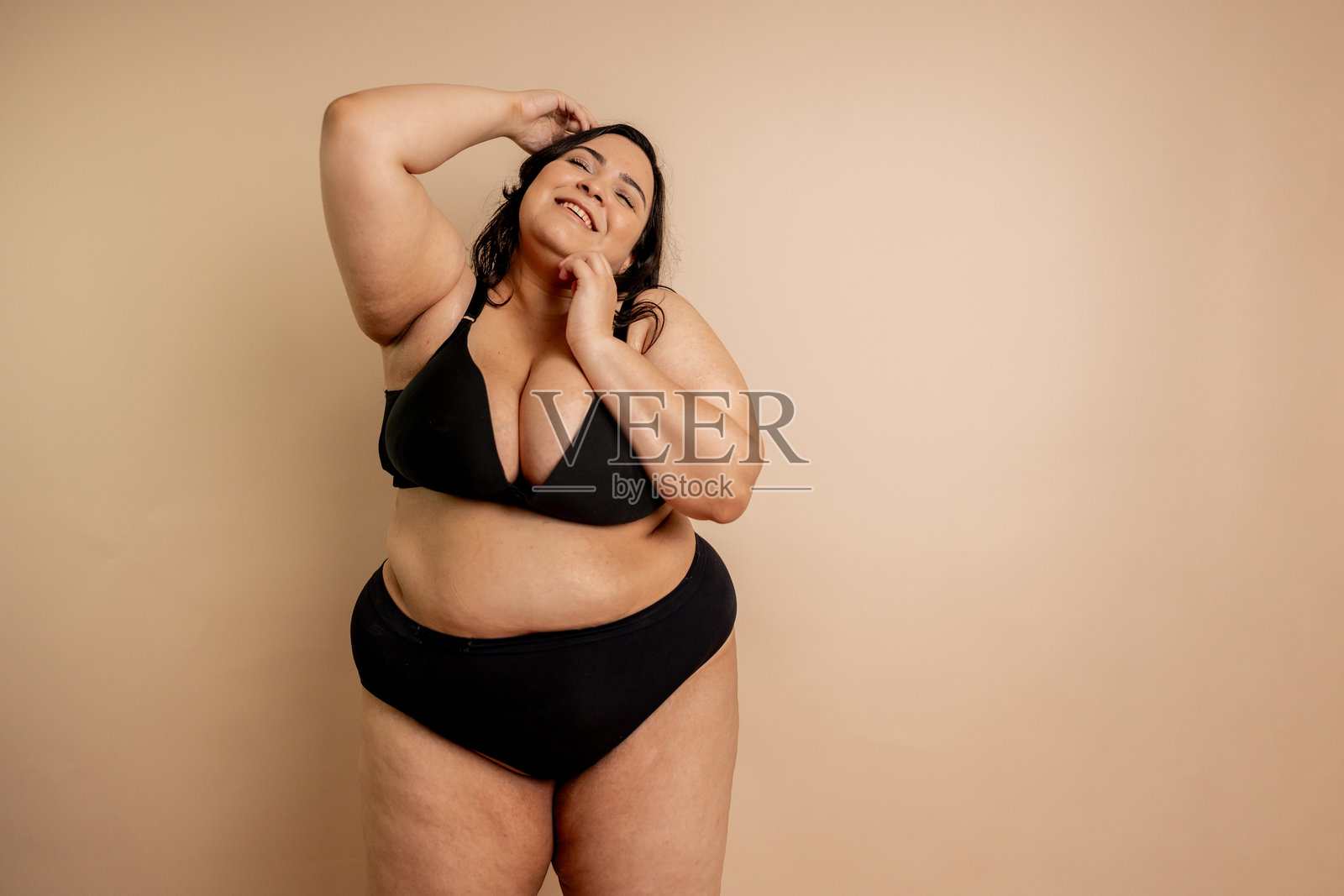 在米色背景下的加大码女性肖像摄影照片摄影图片