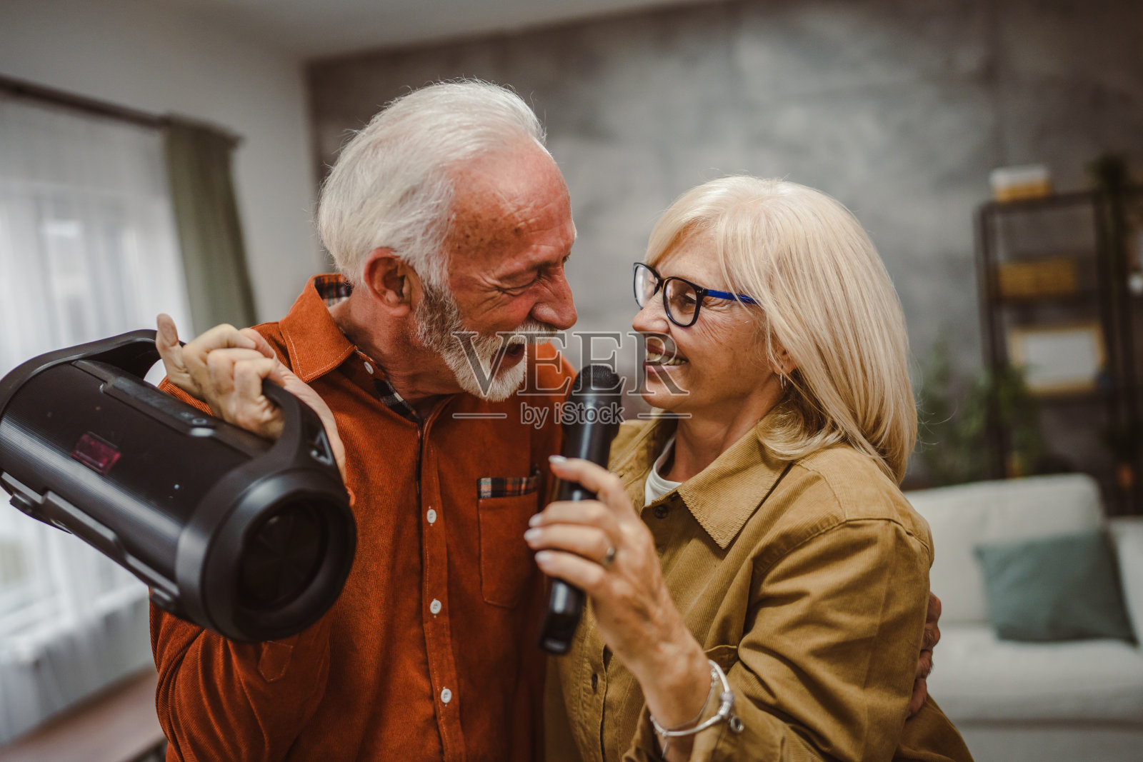 年长的白人夫妇在家一起唱卡拉OK照片摄影图片