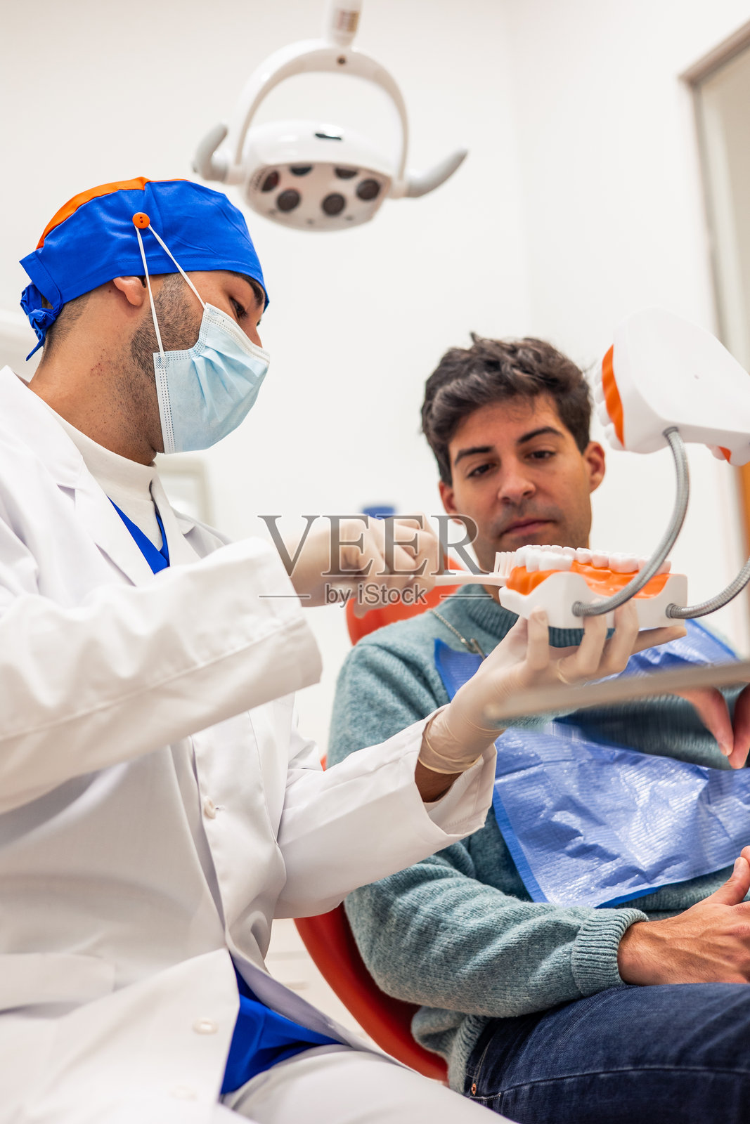 牙医向患者展示正确的刷牙技巧照片摄影图片