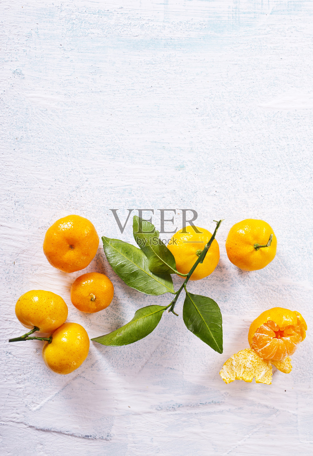 白色木头上的橙色水果和绿色叶子。照片摄影图片