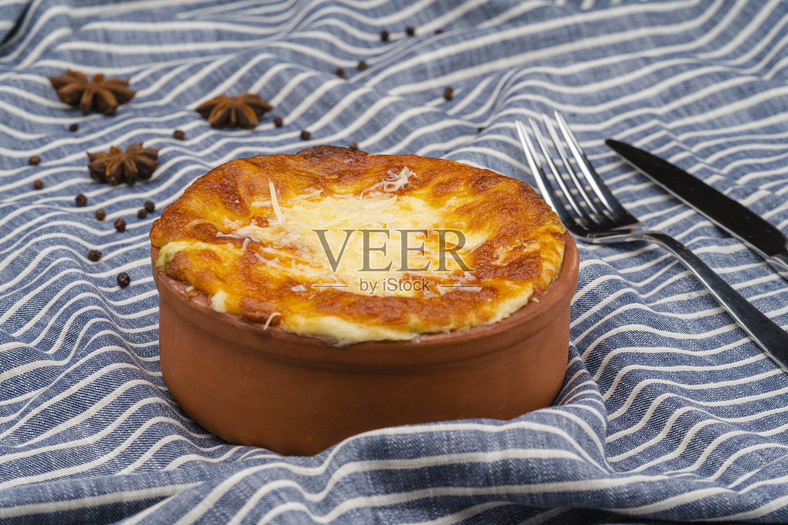 一道盛在碗里的菜肴，配有白酱和卡沙尔奶酪。美味的烤菜。照片摄影图片