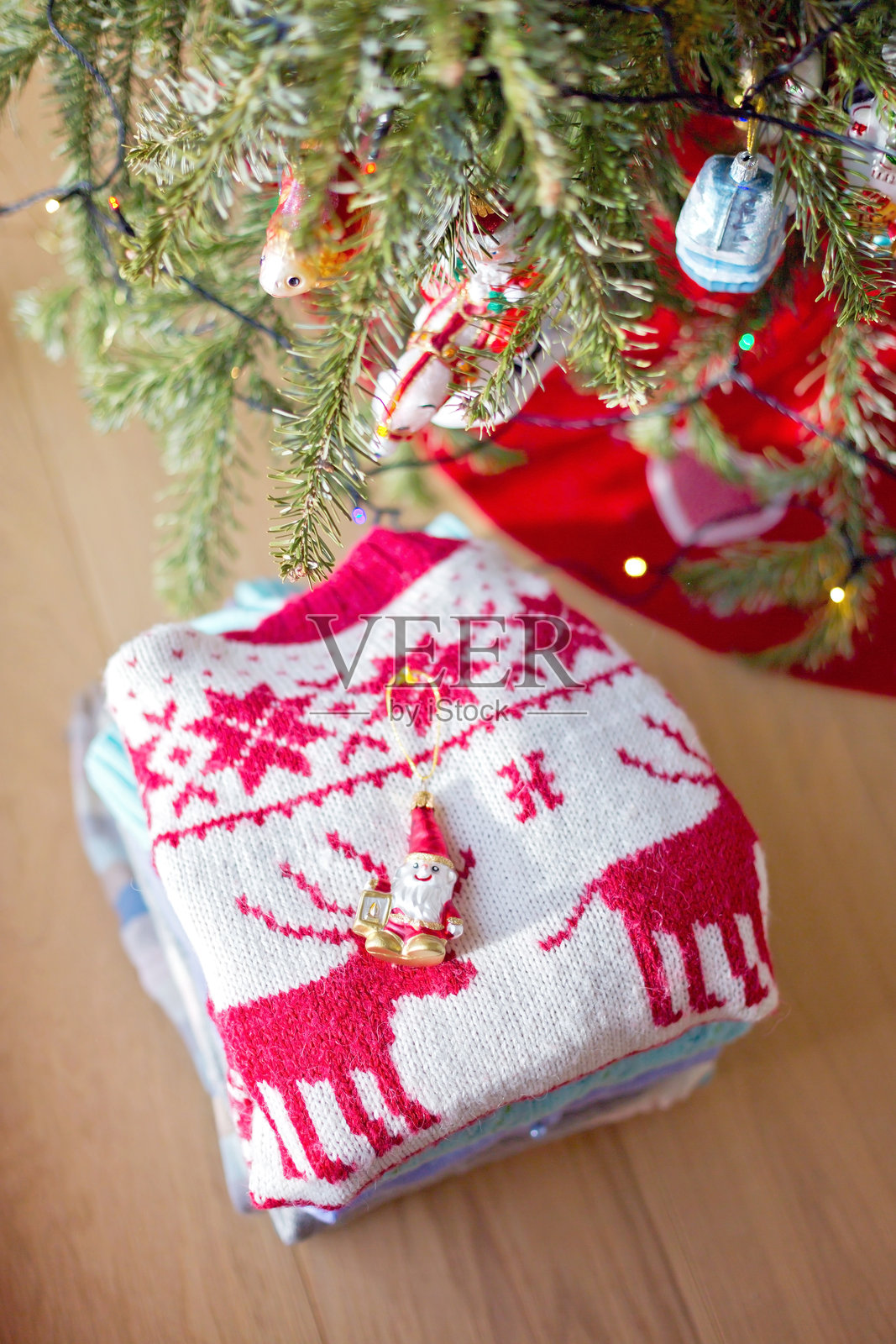 圣诞树前一堆毛衣上的圣诞装饰品照片摄影图片