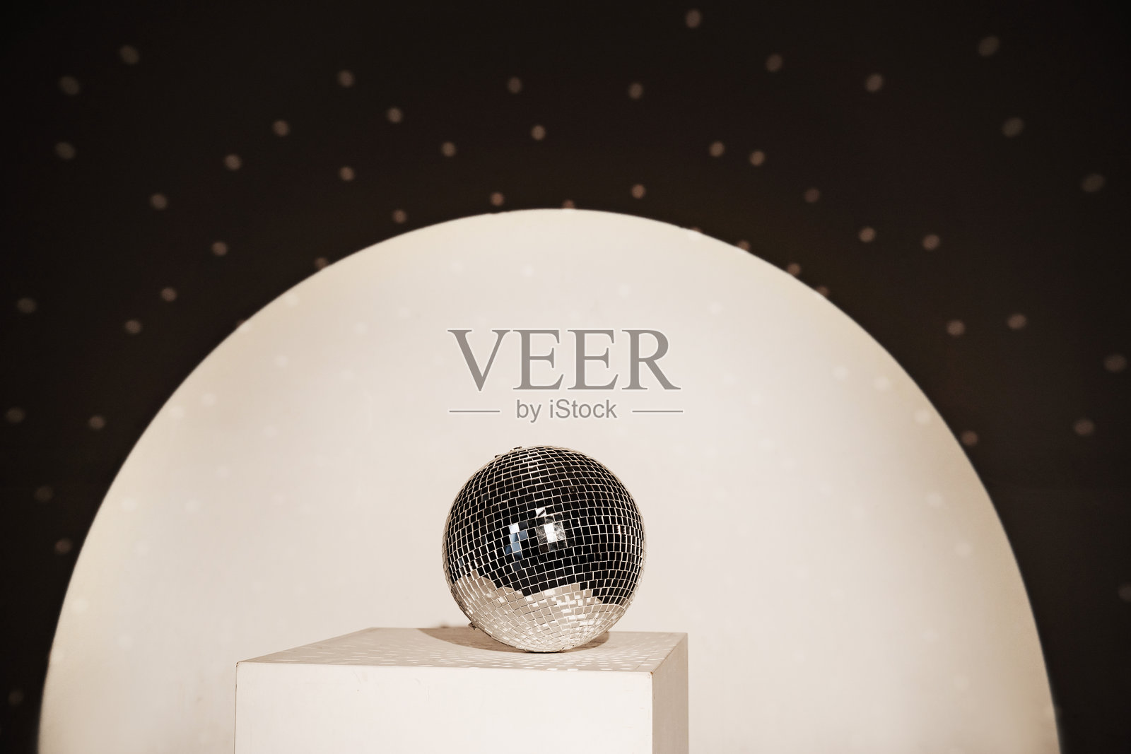 闪亮的迪斯科镜球将光线反射到房间的各个角落。为夜总会派对增添色彩和明亮的装饰。照片摄影图片