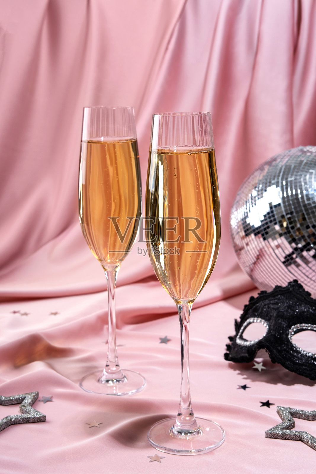 新年横幅。粉色背景上的节日夜晚派对，配有迪斯科球和香槟酒杯。适合海报、传单或卡片设计的庆祝背景。照片摄影图片