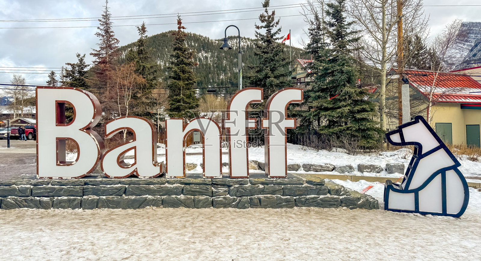 班夫的标志在雪白的冬季景观中骄傲地屹立着，成为前来这个如画小镇的游客的热情欢迎。照片摄影图片