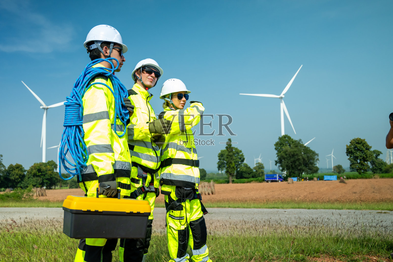 一名穿着安全装备的工程师在可再生能源领域仔细检查风力涡轮机的基础。照片摄影图片