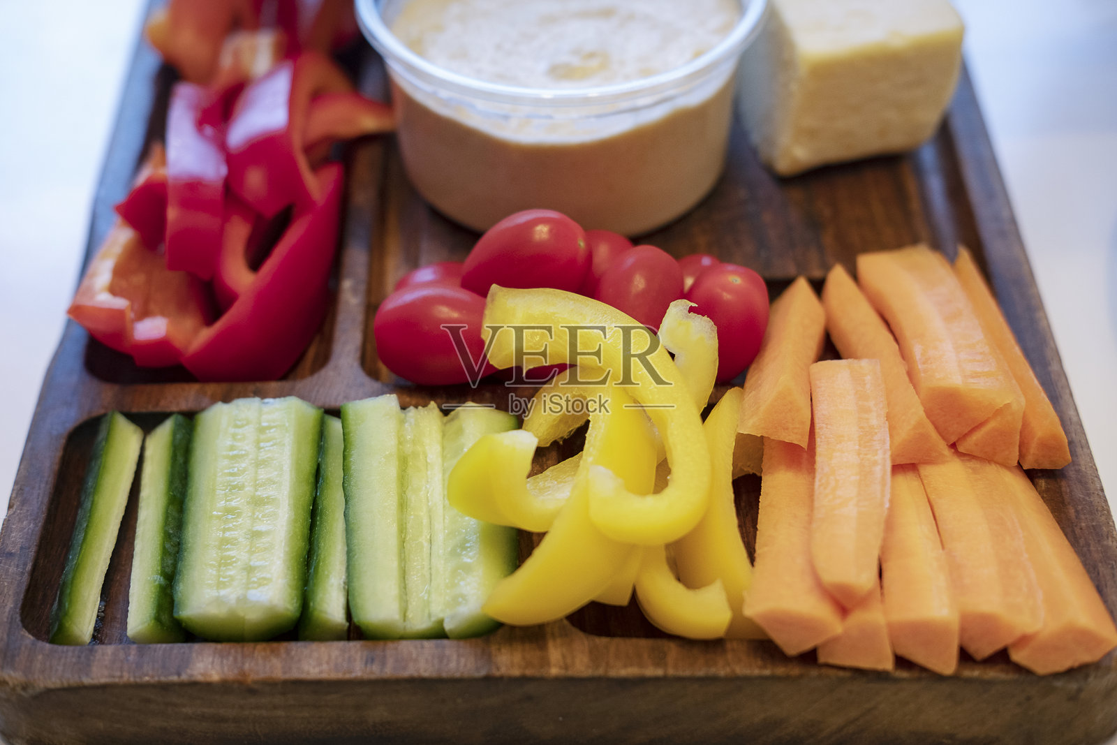 新鲜蔬菜拼盘，包括胡萝卜、黄瓜、彩椒条和樱桃番茄的健康组合照片摄影图片