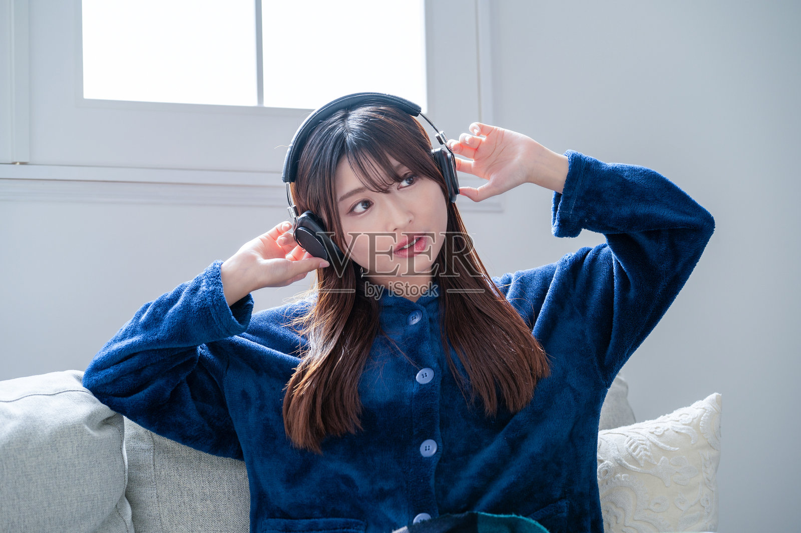 冬天，一位日本女性在客厅里听音乐照片摄影图片