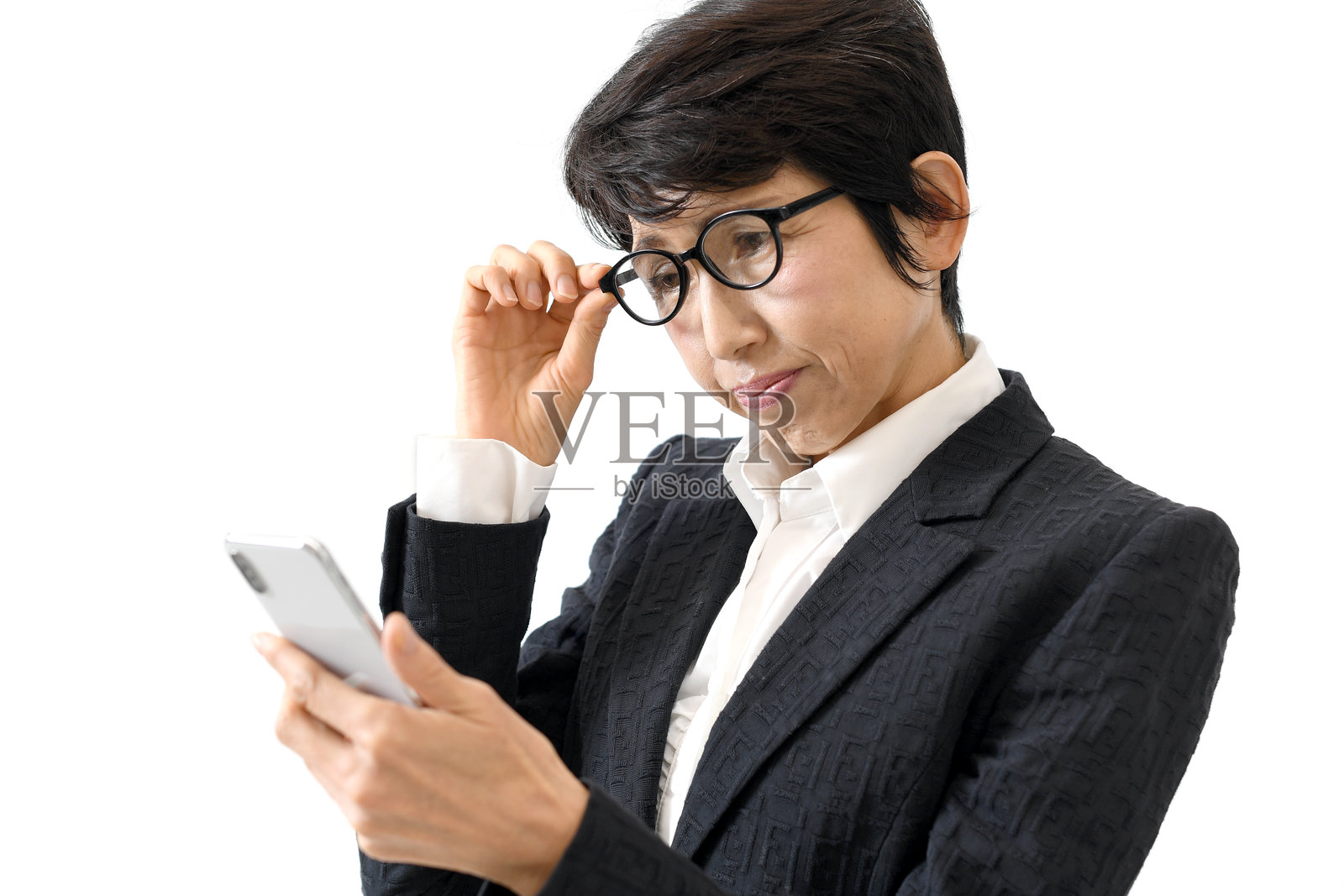 一位中老年亚洲女性因老花眼而看着智能手机照片摄影图片