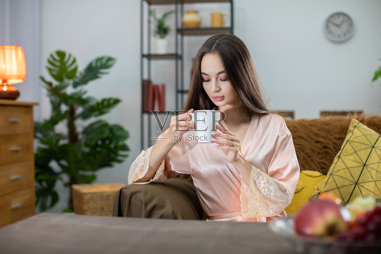 在阳光明媚的舒适客厅里，享受轻松的早晨，品味茶香。照片摄影图片