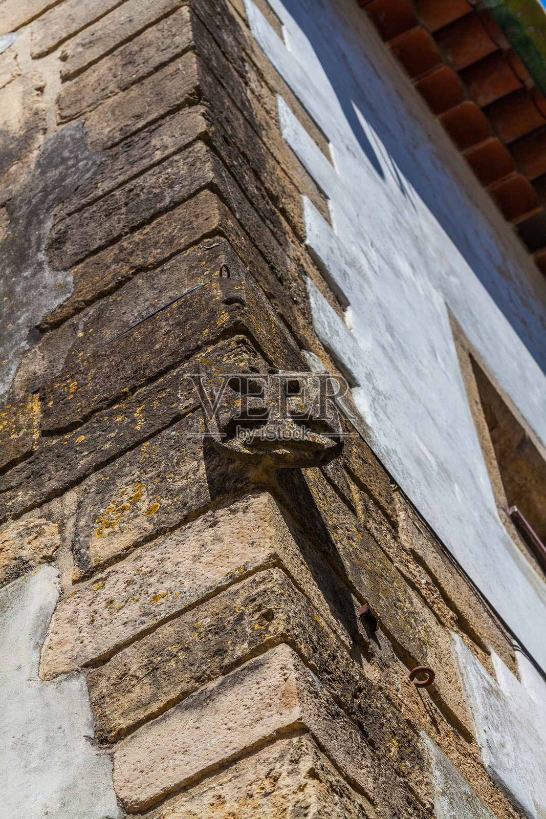 一只风化的石头石像鬼，栖息在一座历史建筑的角落上照片摄影图片