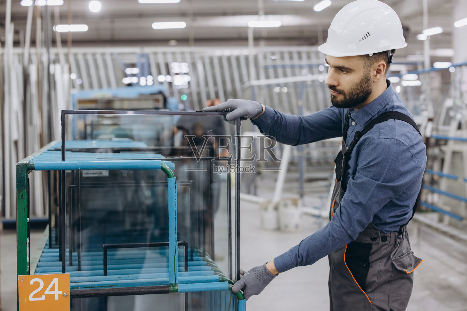 工厂工人正在处理用于PVC窗户和门生产的玻璃板照片摄影图片