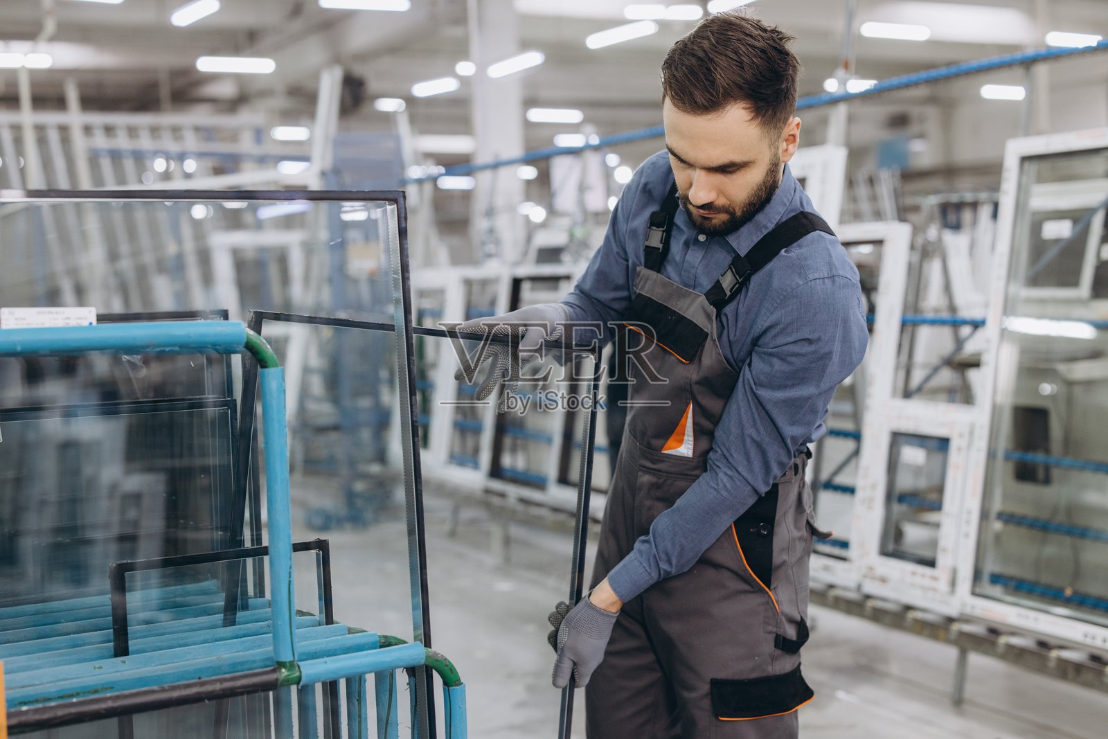 工厂工人在检查PVC窗户生产用的玻璃板照片摄影图片