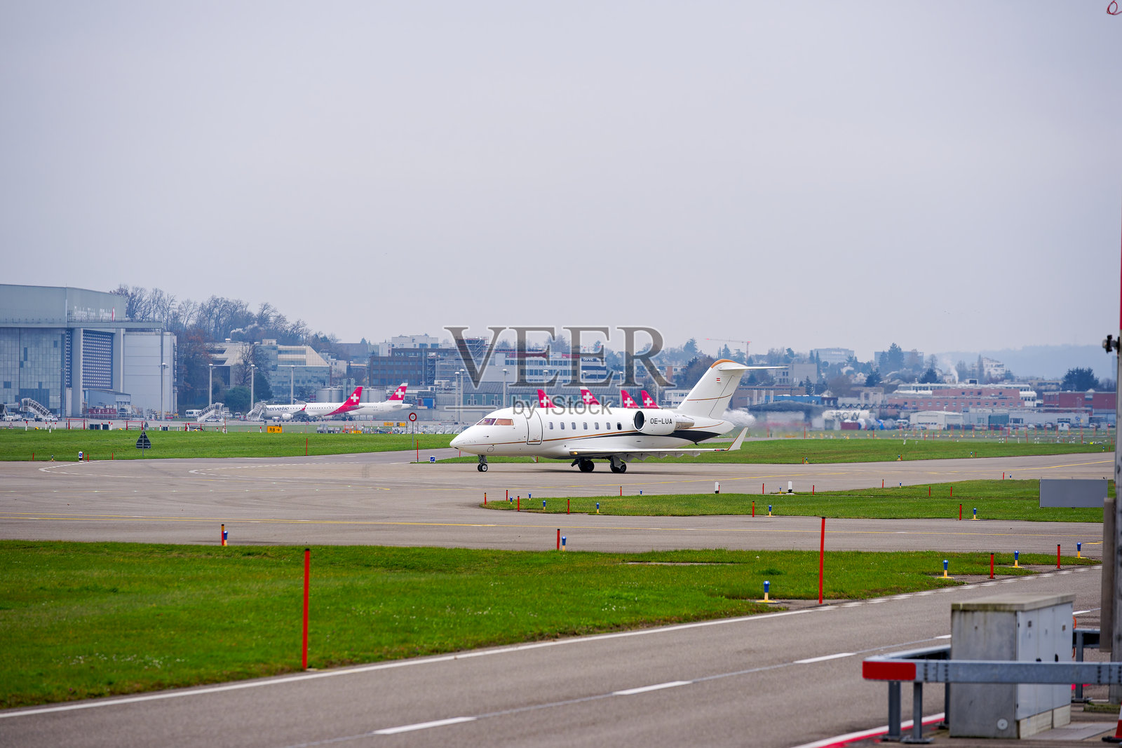 私人飞机侧视图，豪华喷气式飞机庞巴迪挑战者650，注册号OE-LUA，在瑞士苏黎世克洛滕机场滑行至跑道，背景为灰色的秋日。照片摄影图片