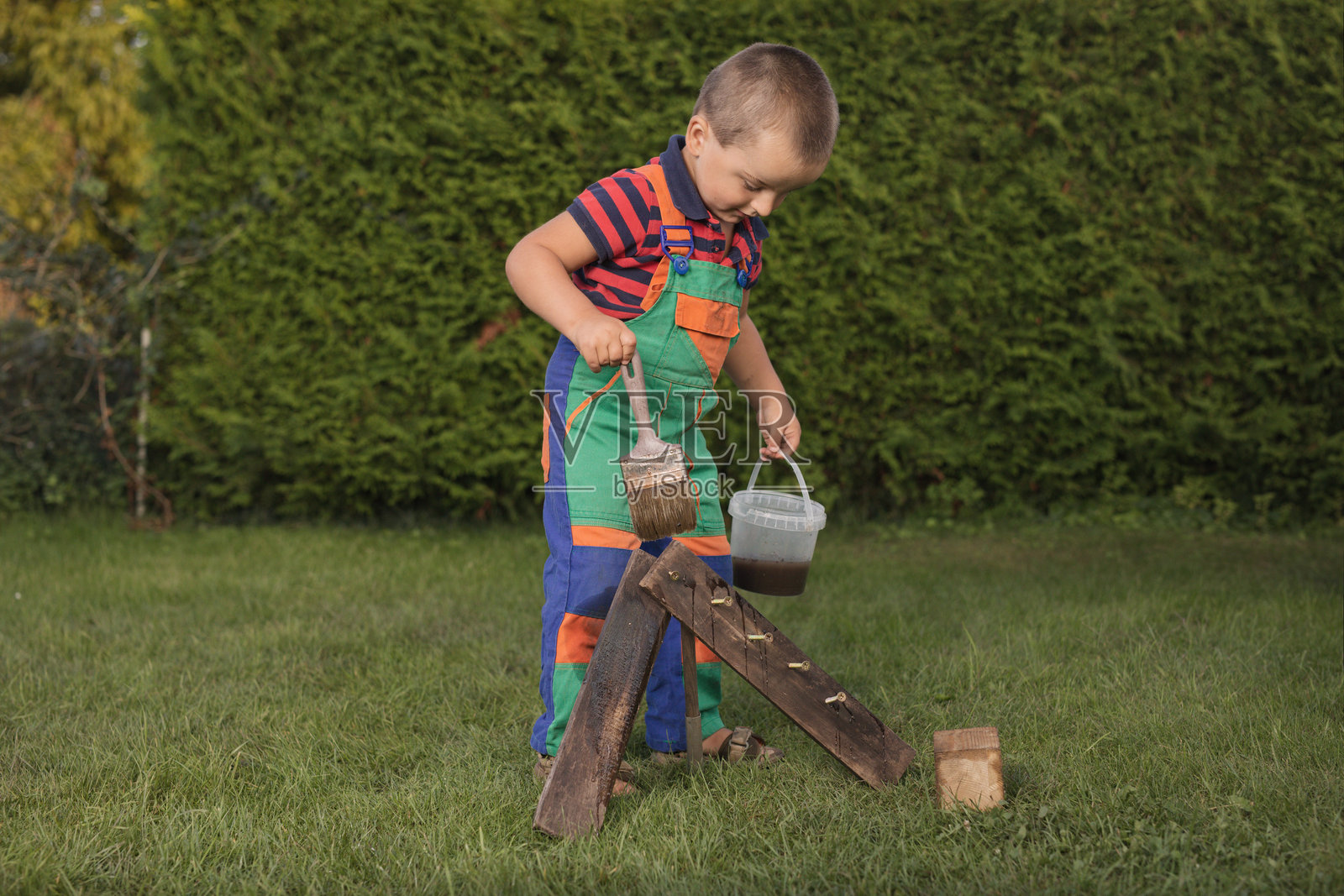 小工匠在花园角落使用多种电动工具照片摄影图片