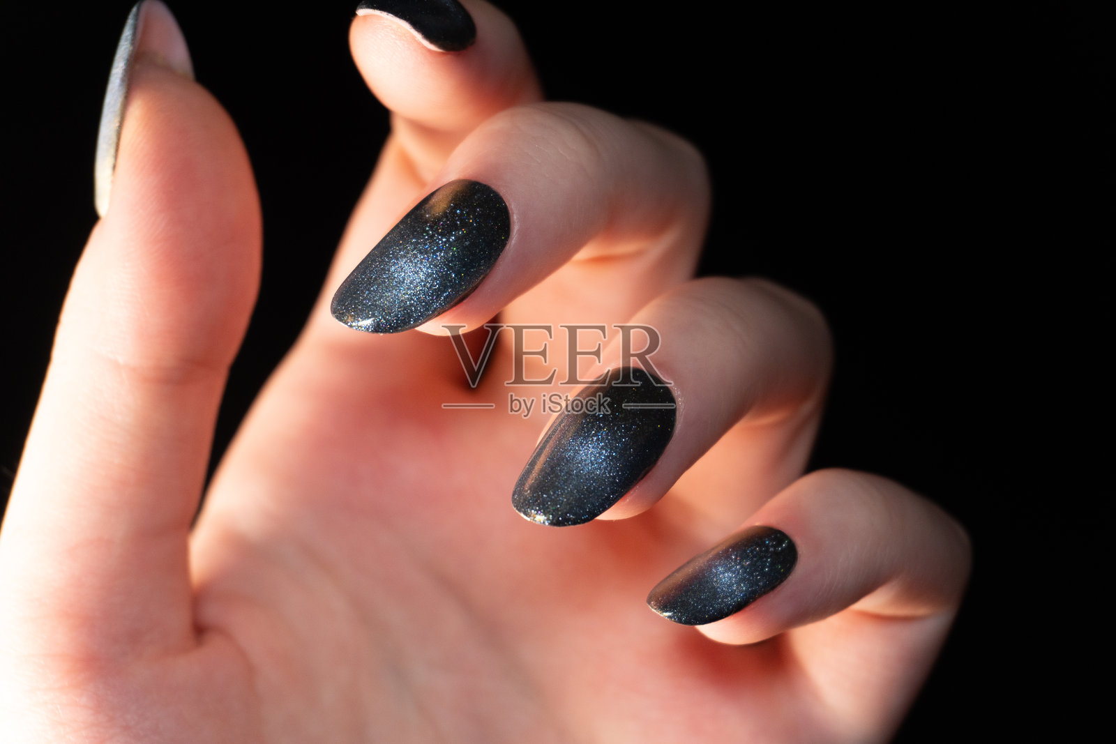 现代高科技风格的美甲，采用猫眼指甲油的铬色效果，辅以光泽亮点，显得独特而精致。照片摄影图片