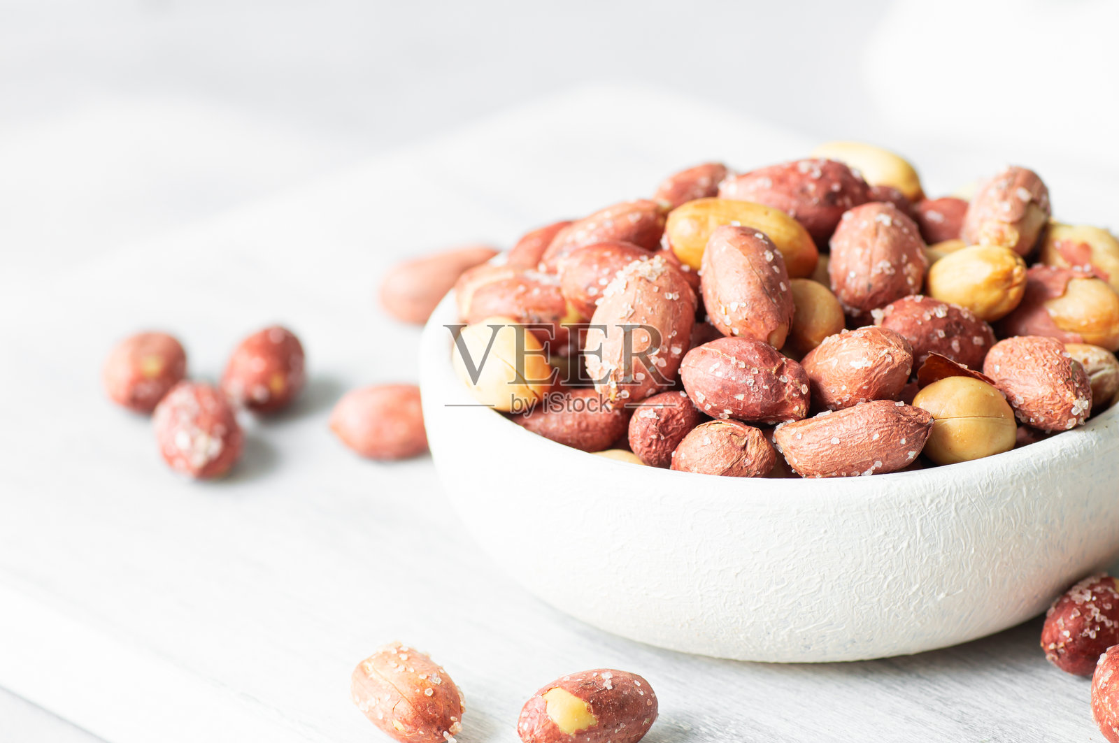 无壳烤咸花生放在碗中或麻布袋里，背景为乡村风格，坚果的概念照片摄影图片