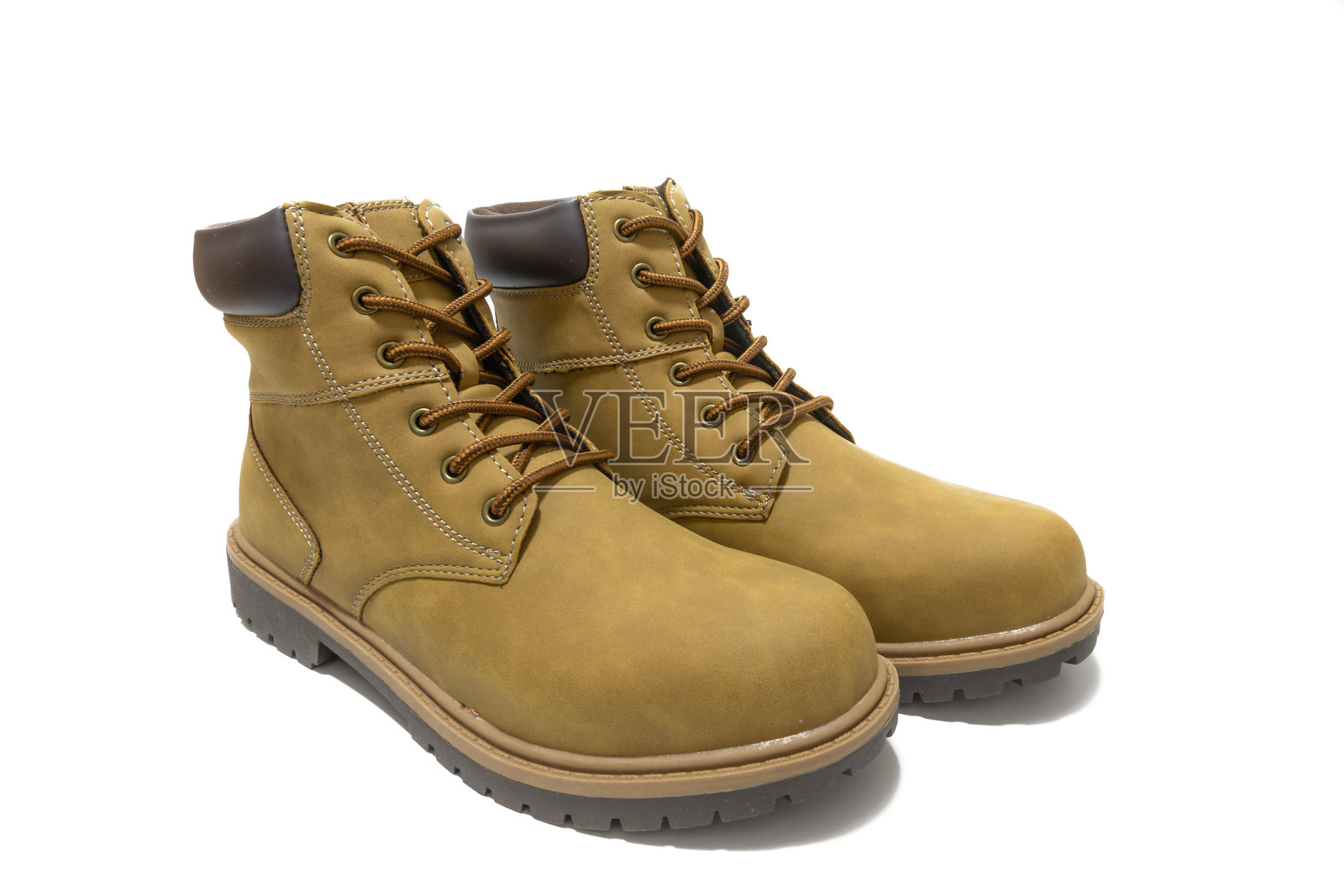 时尚的芥末色皮靴，适合户外探险和日常舒适。背景为白色。照片摄影图片