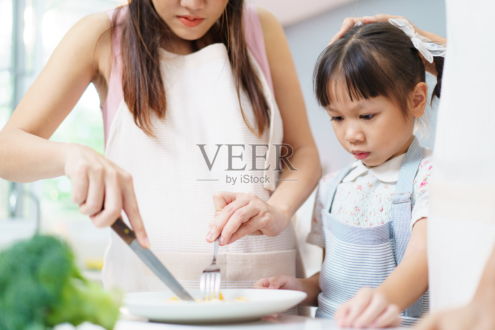 亚洲家庭在厨房一起做饭。照片摄影图片