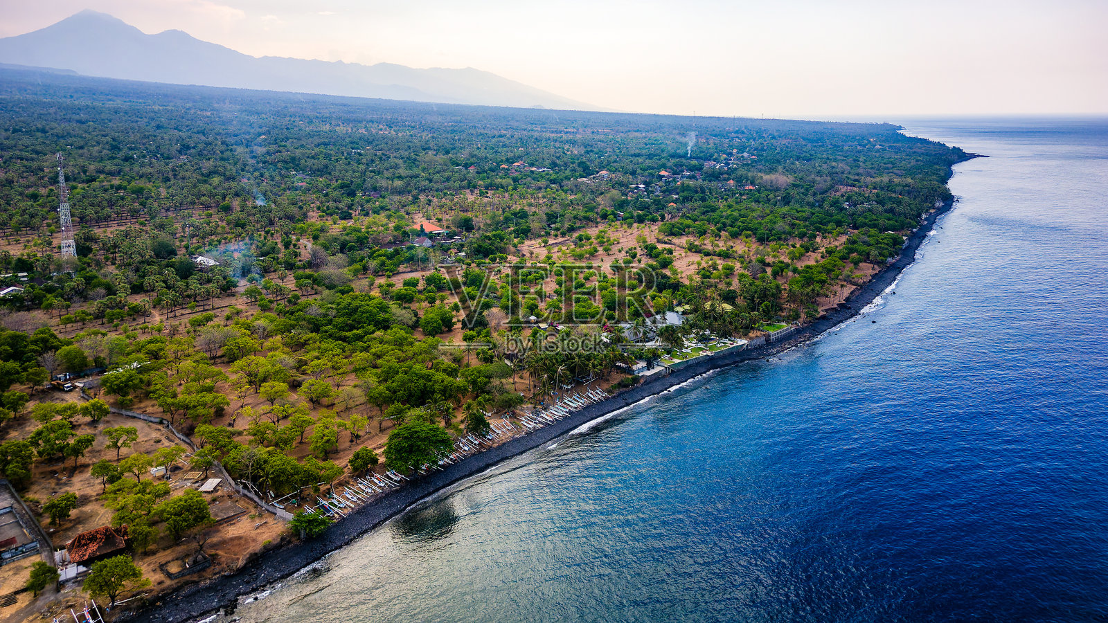 巴厘岛印度尼西亚黑色火山沙滩与郁郁葱葱的热带植被的鸟瞰图照片摄影图片