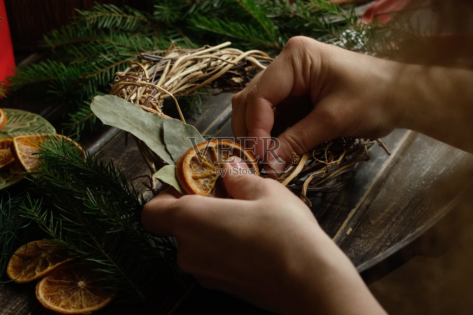 制作圣诞花环的人。照片摄影图片