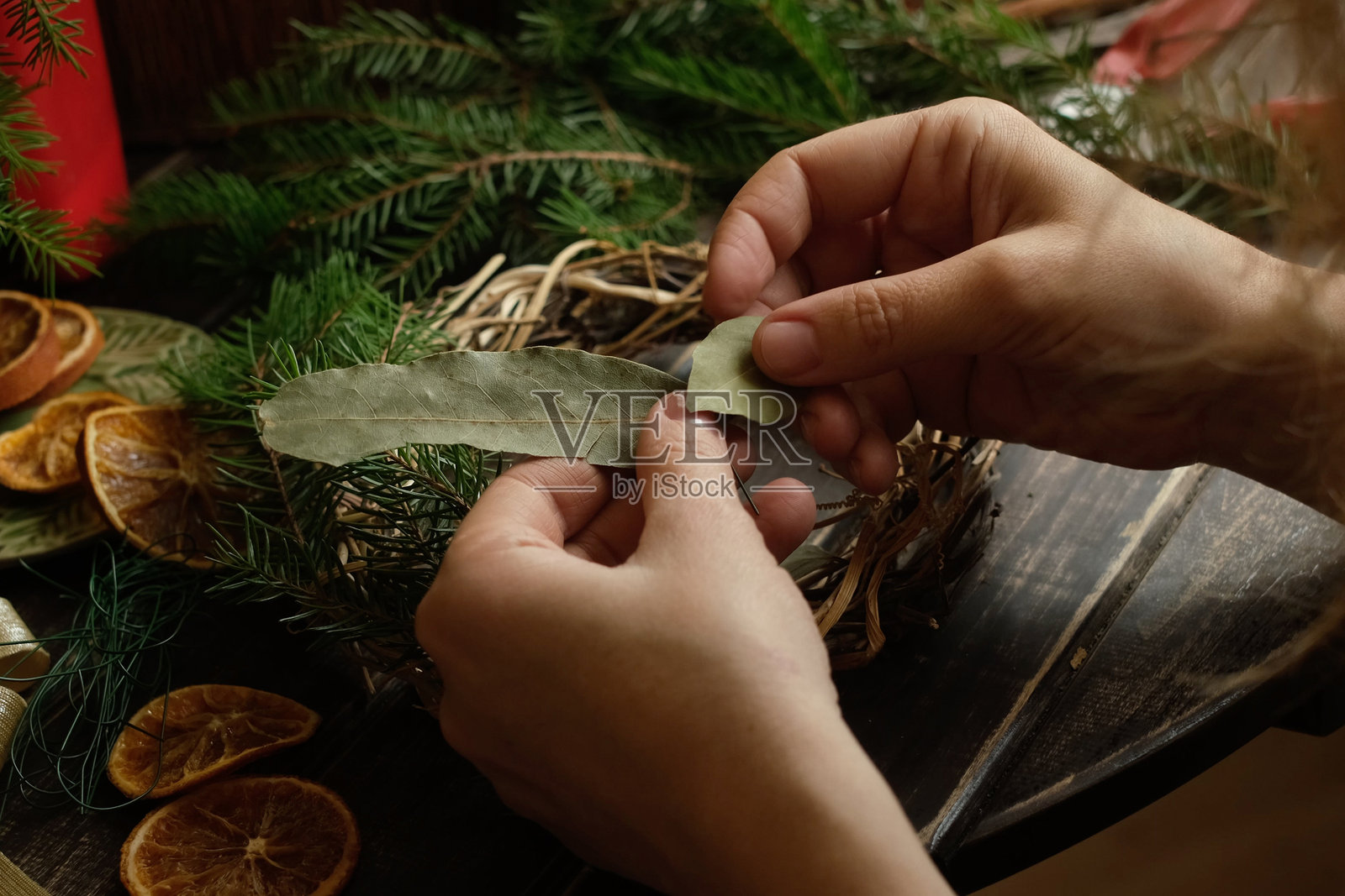 制作圣诞花环的人。照片摄影图片