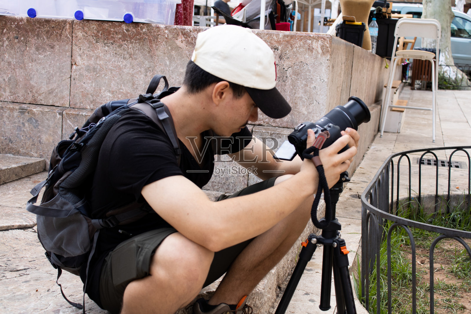 年轻的冒险者在古老村庄中用三脚架拍照照片摄影图片