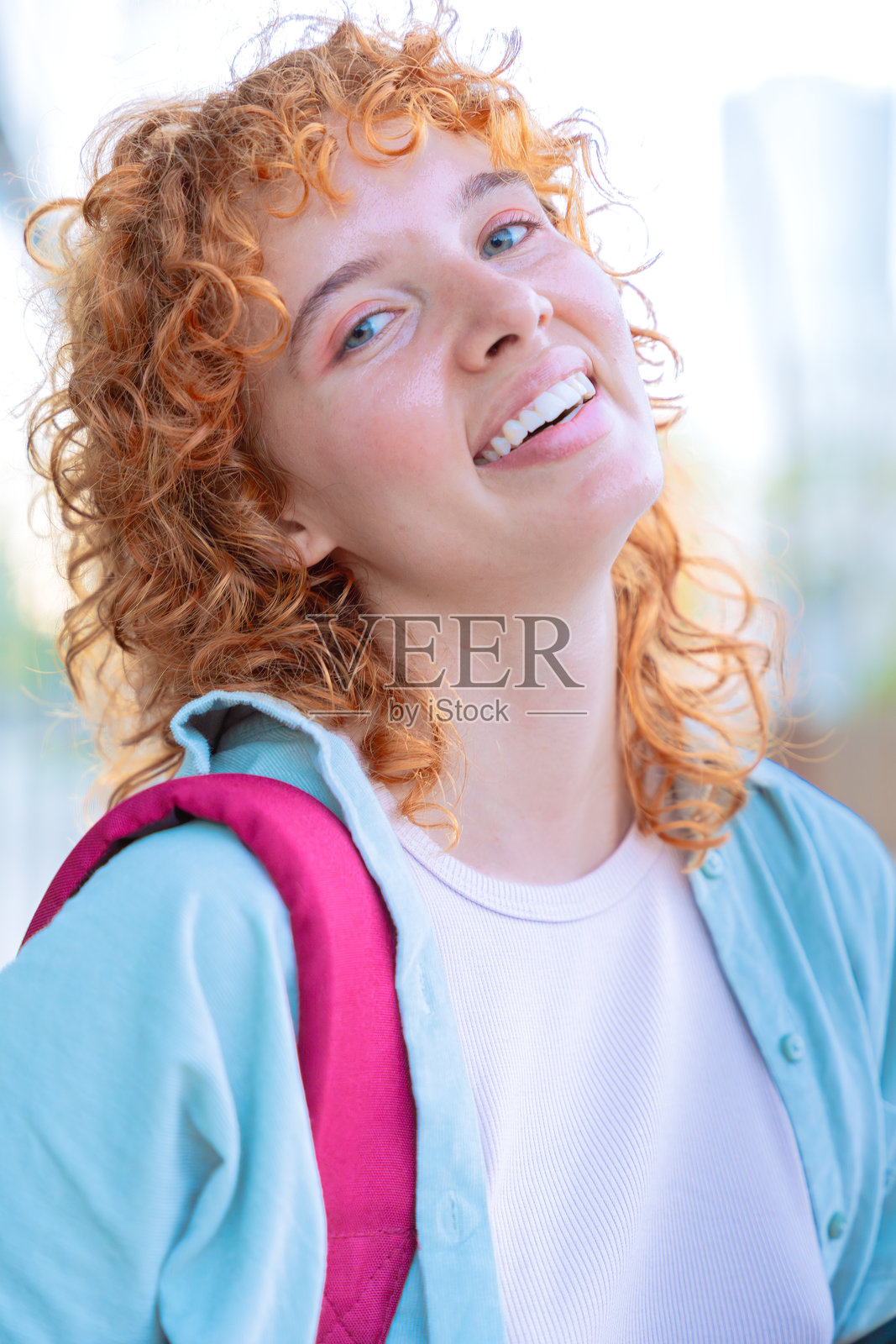 在自然环境中微笑的年轻女性肖像，扎着辫子。照片摄影图片