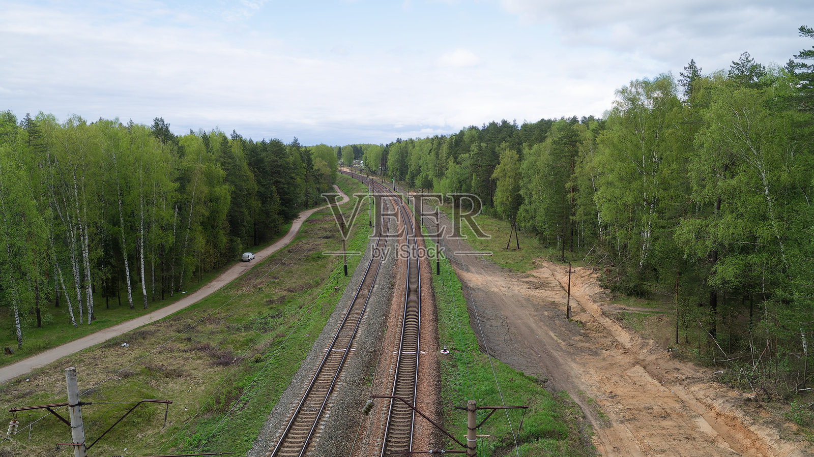 火车沿着森林旁的轨道行驶照片摄影图片