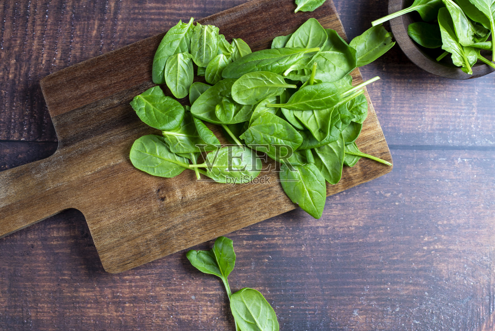 木桌背景上的小碗里装着菠菜照片摄影图片