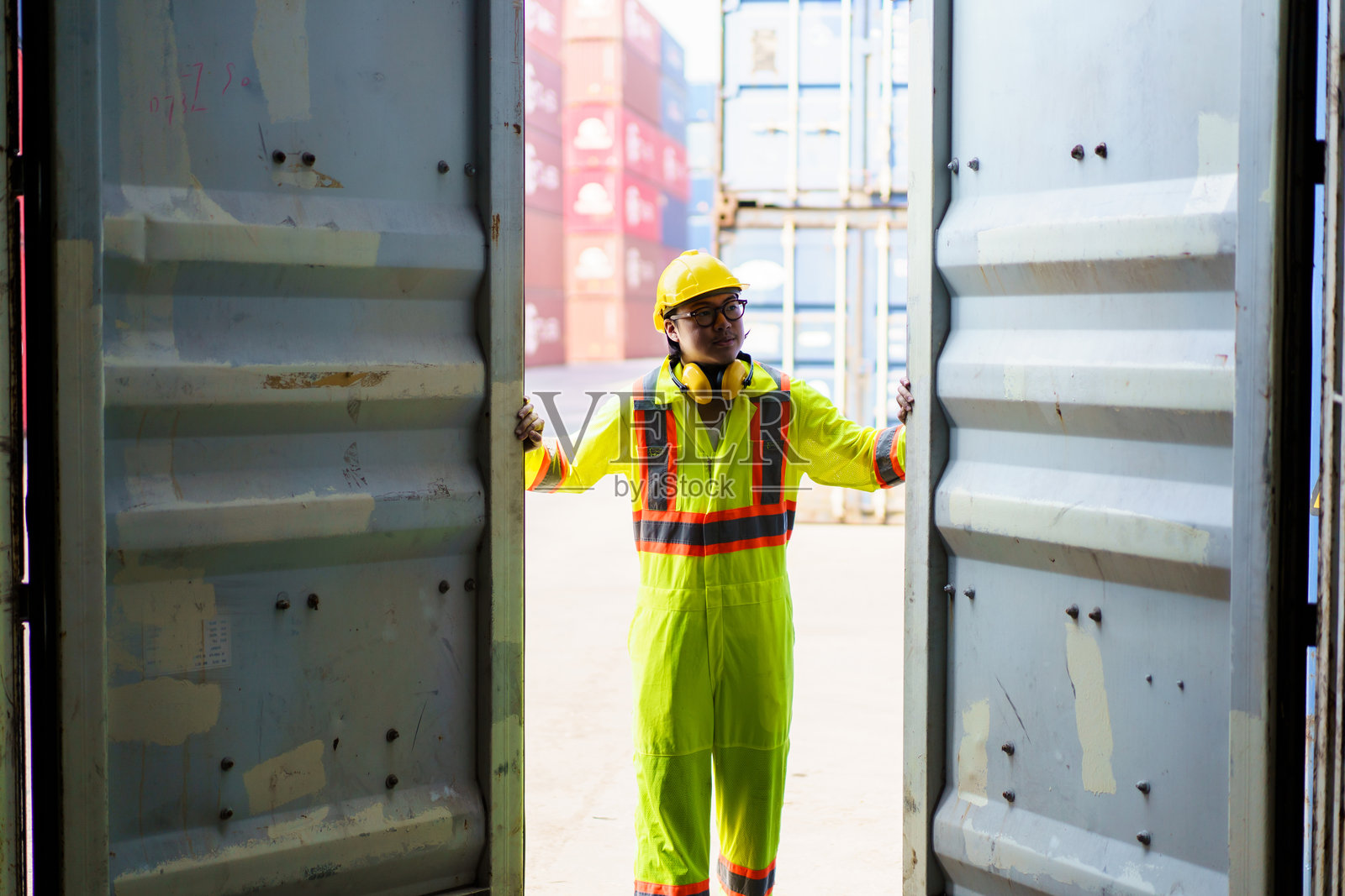 集装箱场或船厂工人在检查集装箱。照片摄影图片