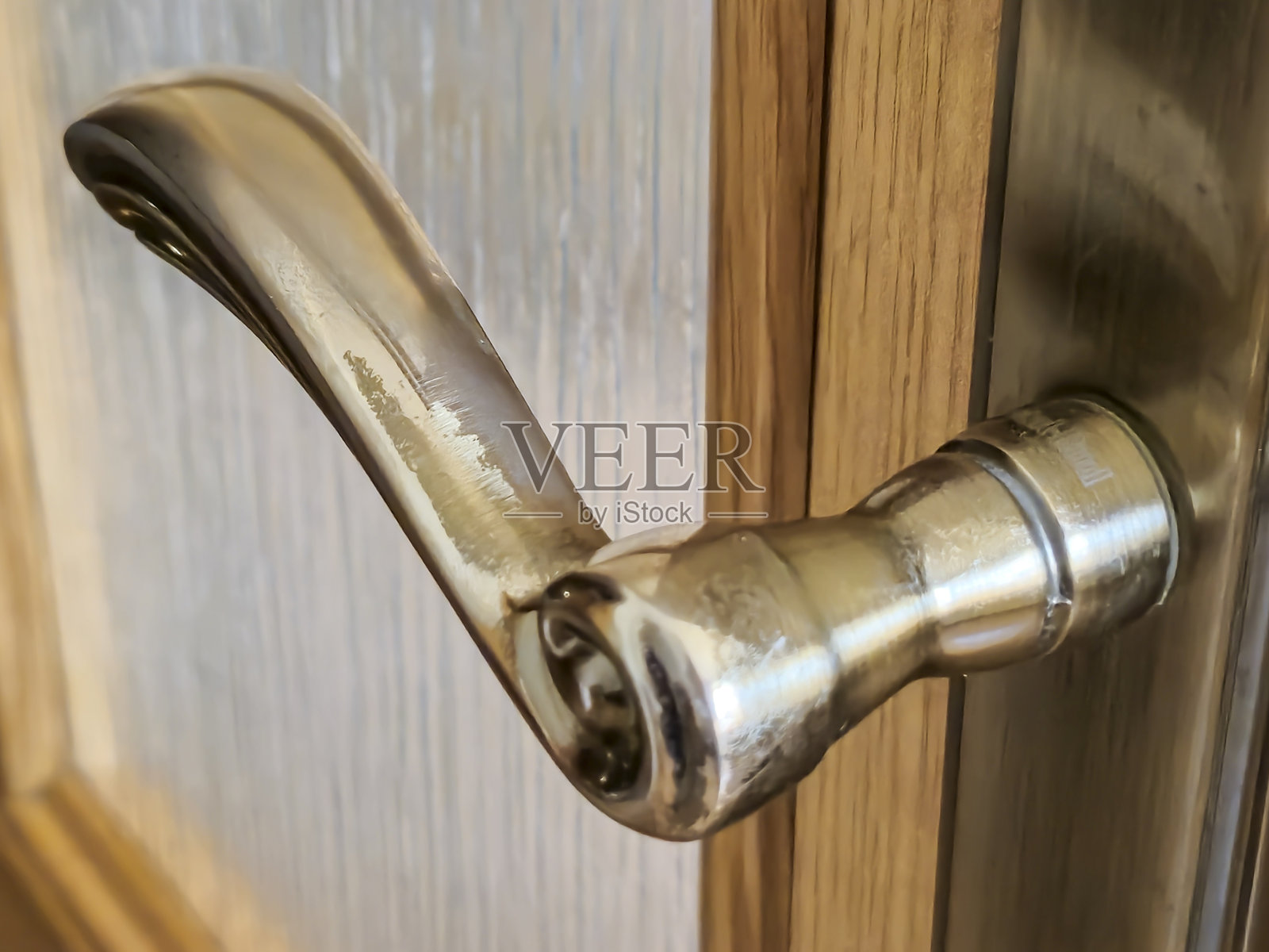 精致的门把手特写，展示了复杂的设计细节，背景为木质门。非常适合家居装饰主题和五金设计创新。照片摄影图片
