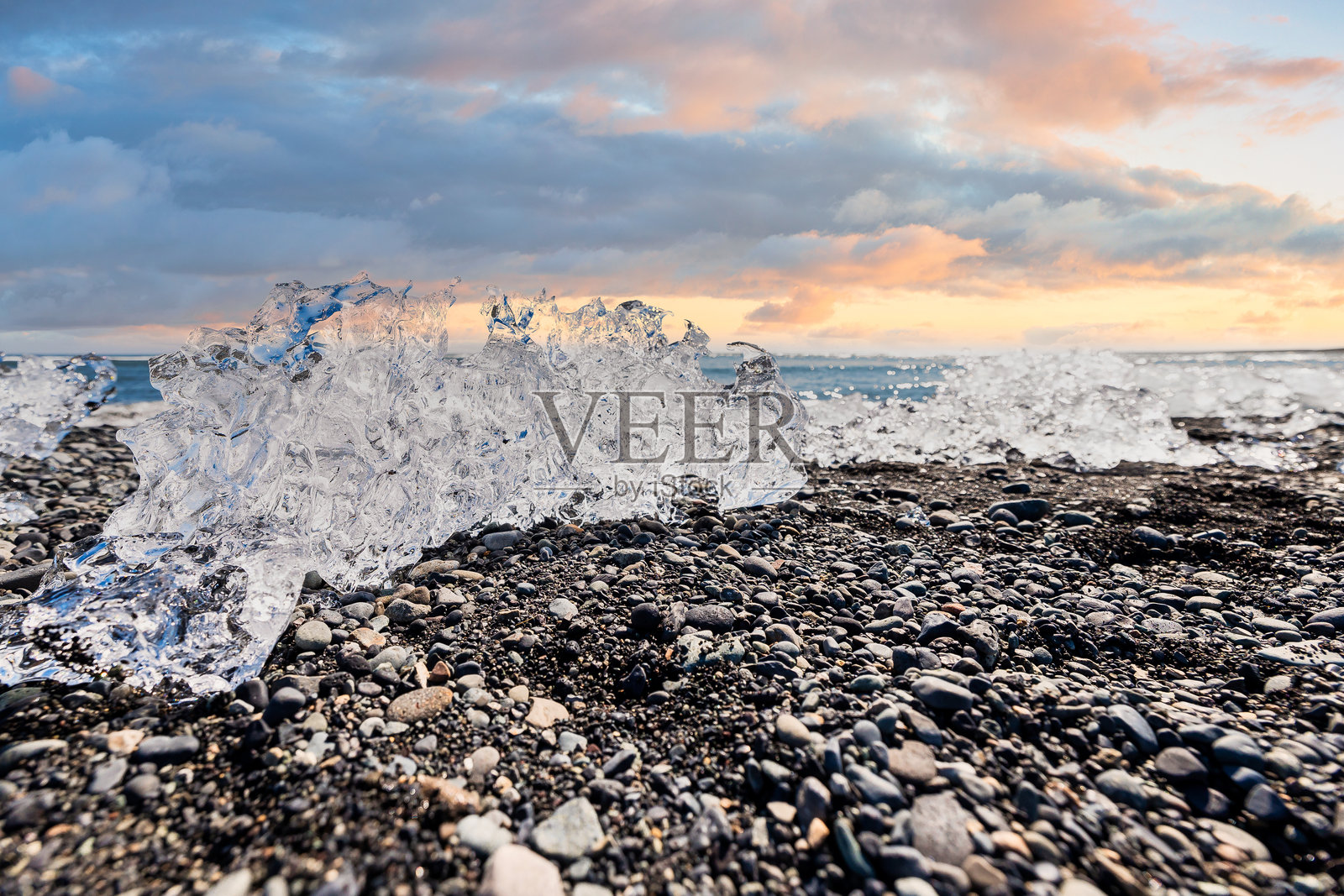 钻石海滩 - 冰岛最受欢迎的旅游目的地，日落时分在卵石海岸上闪烁的冰块形成。照片摄影图片