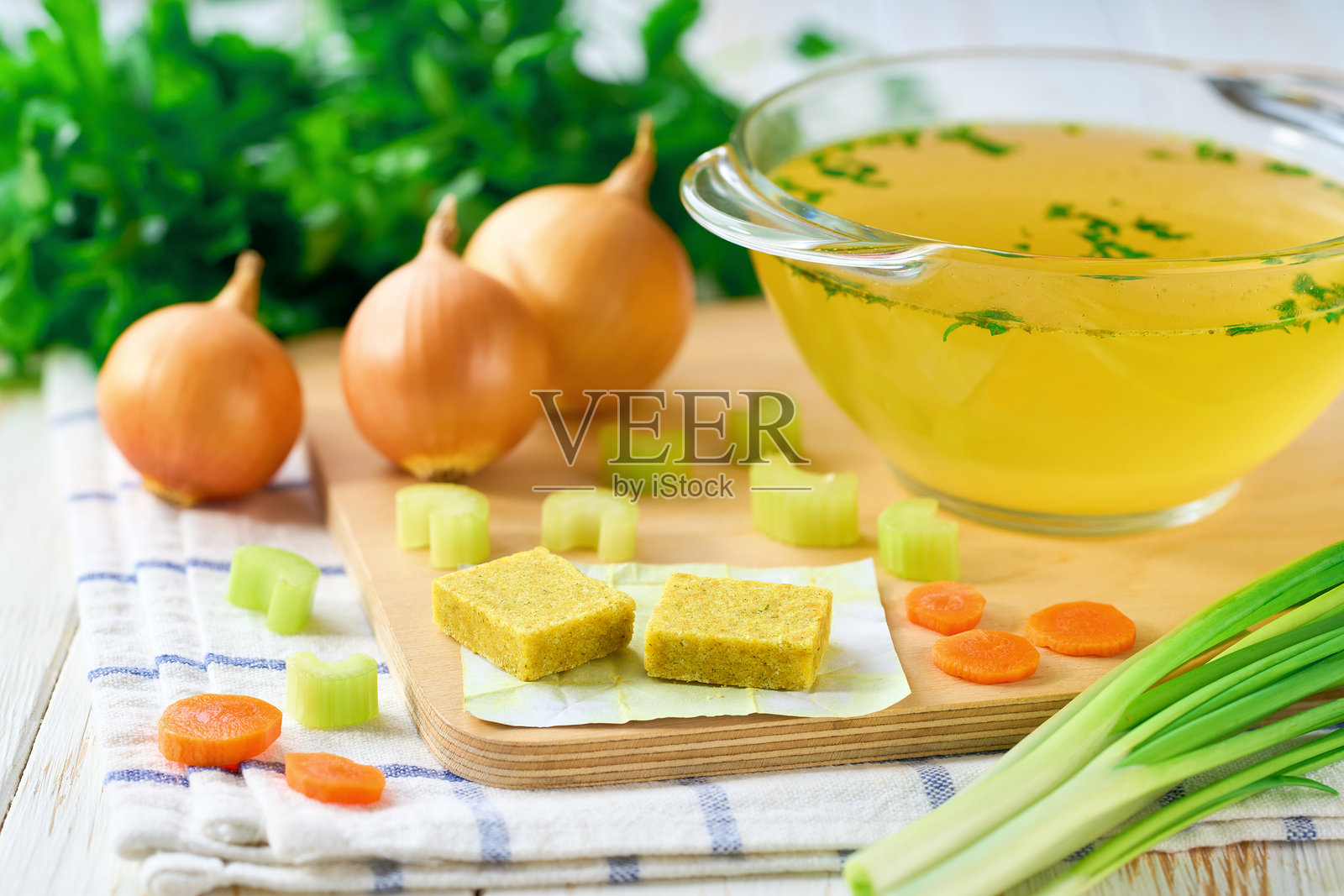 鸡肉高汤块与即食高汤放在碗中，背景是配料。照片摄影图片