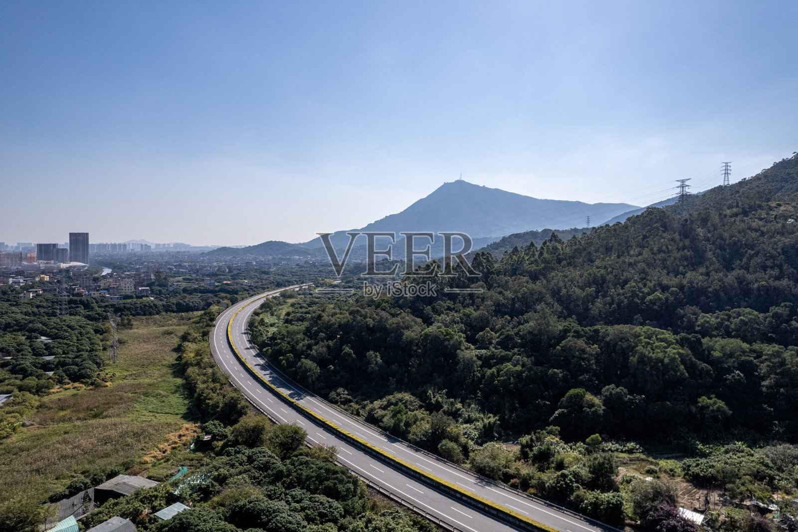 从空中俯瞰穿过山坡和田野的高速公路照片摄影图片