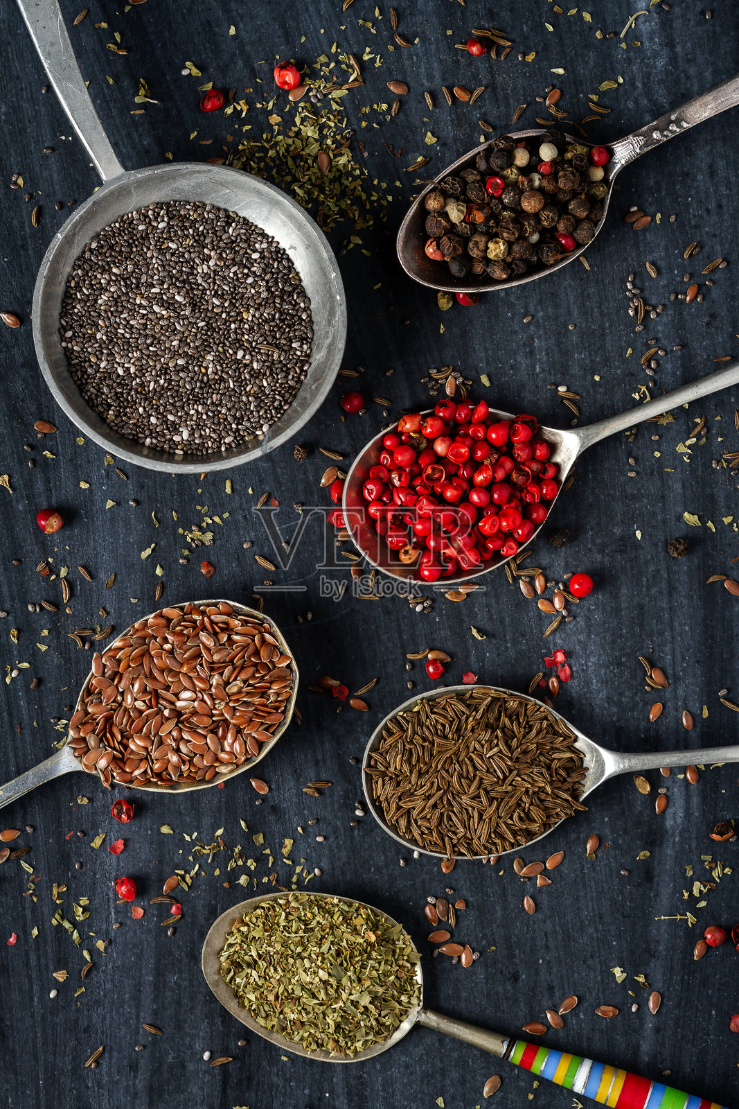 黑色背景上的旧勺子与各种种子和香料照片摄影图片