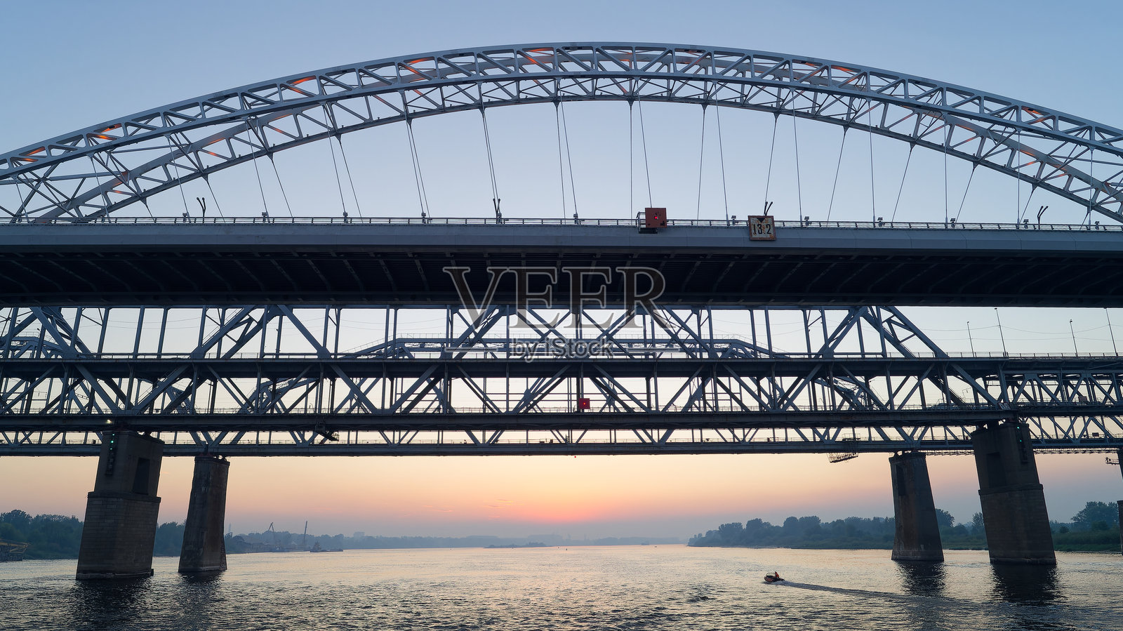 桥梁横跨河流，背景是美丽的日落。照片摄影图片