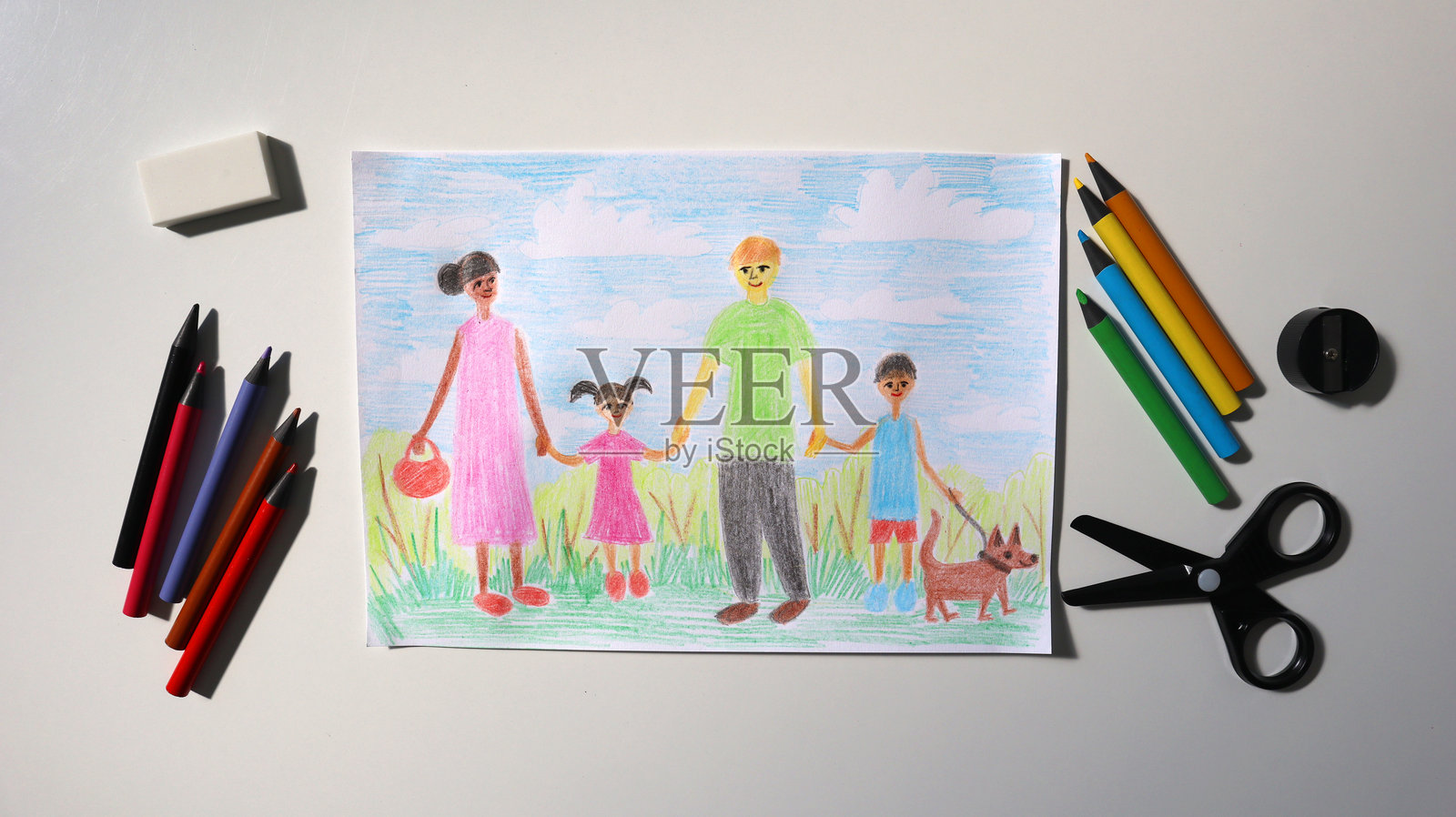 孩子的彩色铅笔画，画中展示了一个家庭。铅笔周围是白色背景，表现出多样化的家庭。照片摄影图片