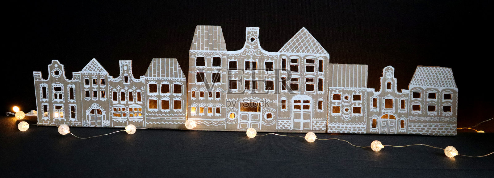 老房子的全景。手工制作。黑色背景。灯串的光芒。照片摄影图片