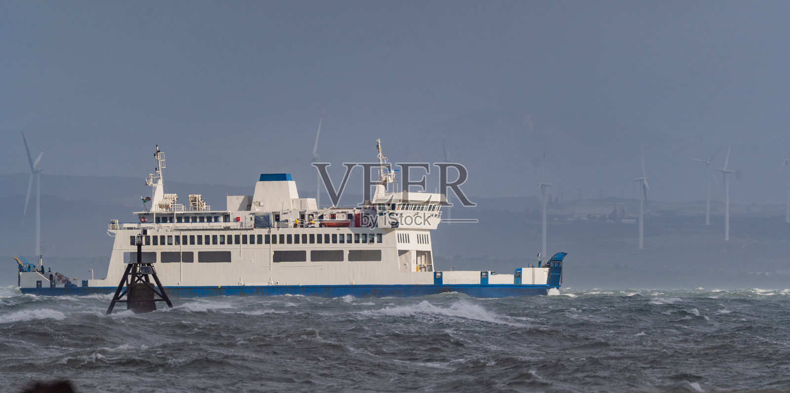 渡轮在近海风电场附近穿越波涛汹涌的海域照片摄影图片