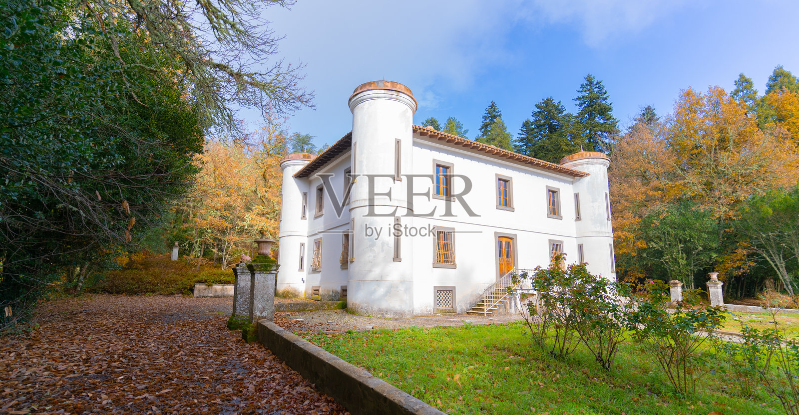 萨丁岛上被秋季树叶环绕的白墙宏伟别墅皮尔西照片摄影图片